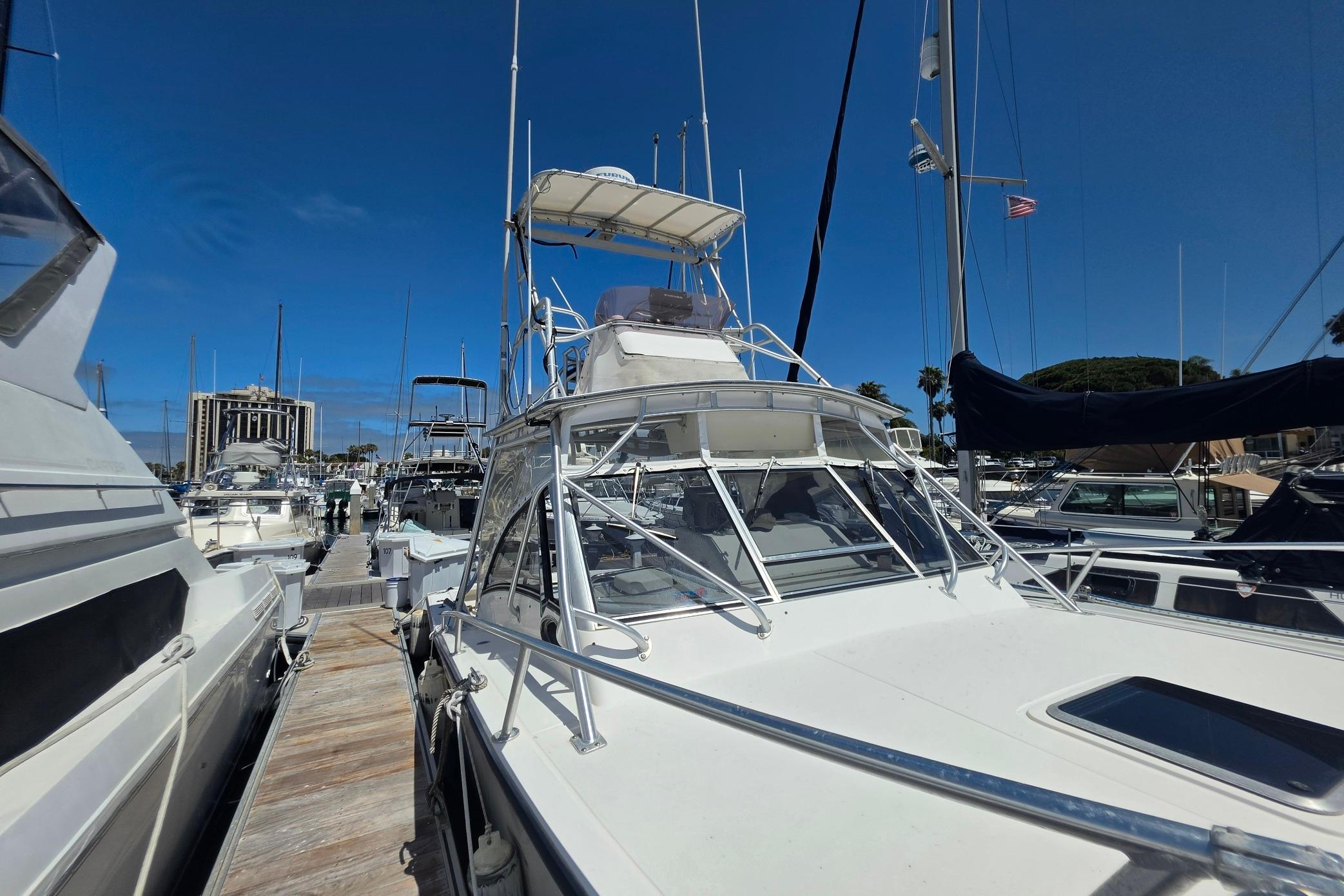 1999 Albemarle 305 Express Fisherman docked at marina under clear blue sky.