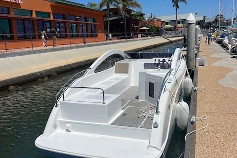 2024 Bracewell 25 boat docked at marina with waterfront buildings in background.