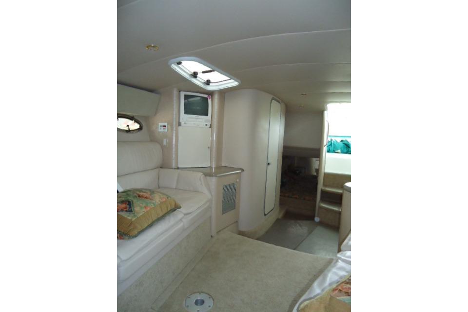 Interior of 1999 Formula 400 Super Sport boat, featuring seating and compact entertainment area.