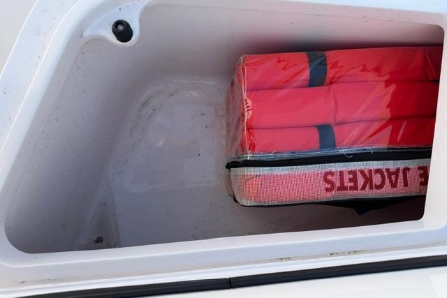 Storage compartment with life jackets on a 2014 Southport 29 FE boat.