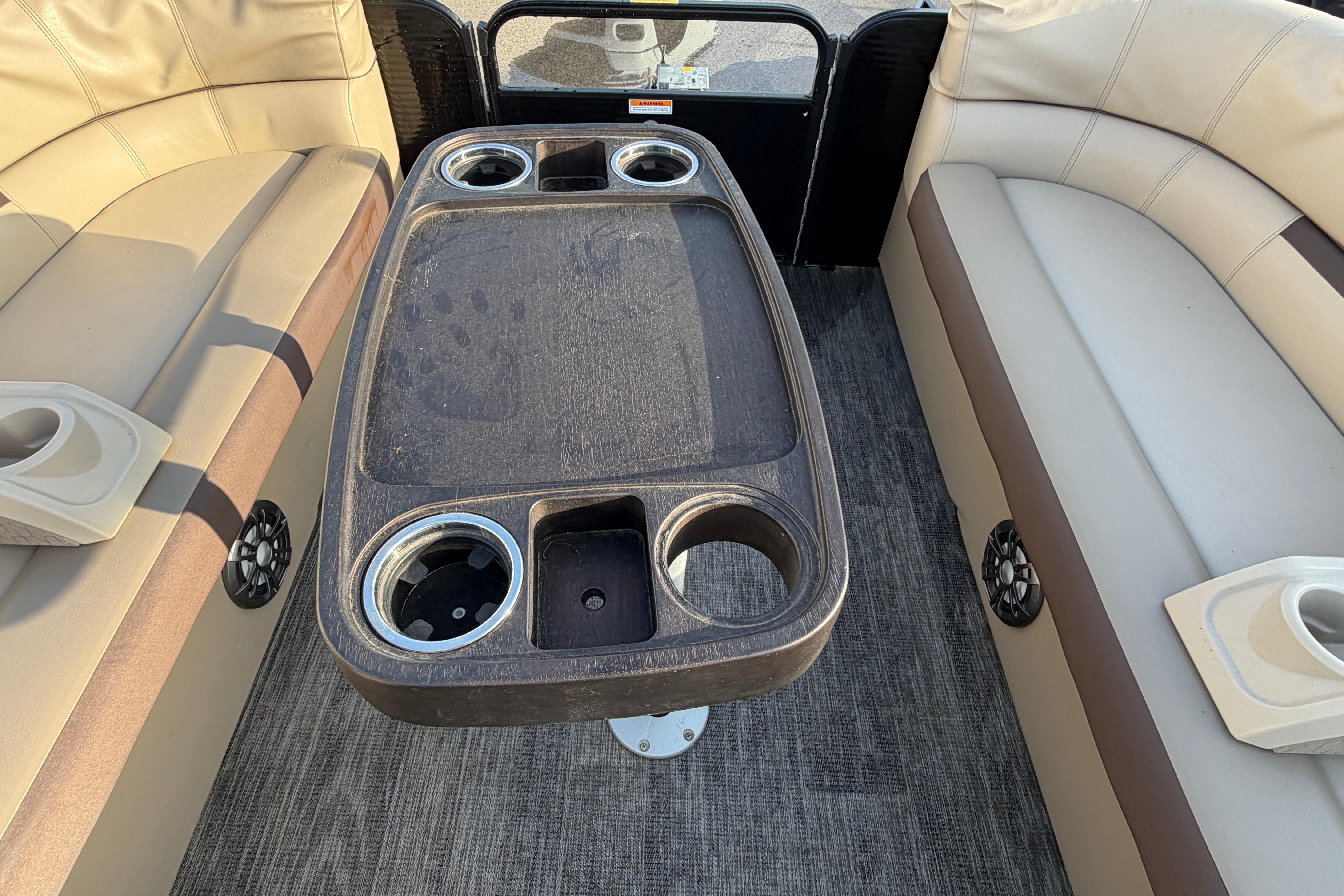 Interior of 2023 Godfrey Sweetwater 2286 C pontoon boat with seating and cup holders.