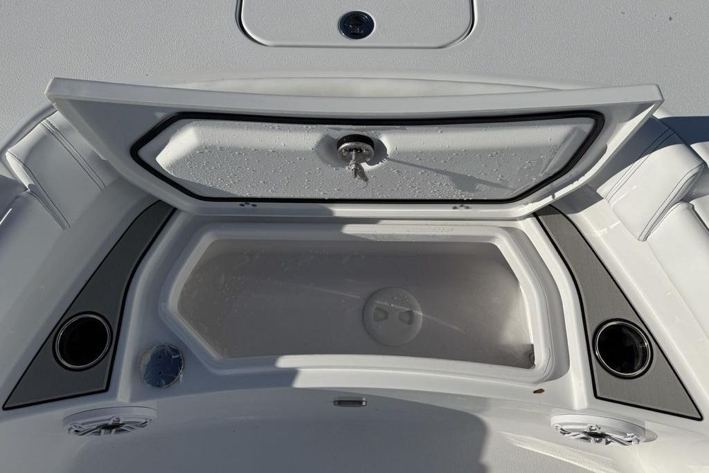 2026 Sportsman Masters 247OE Bay Boat storage compartment with open lid and cup holders.