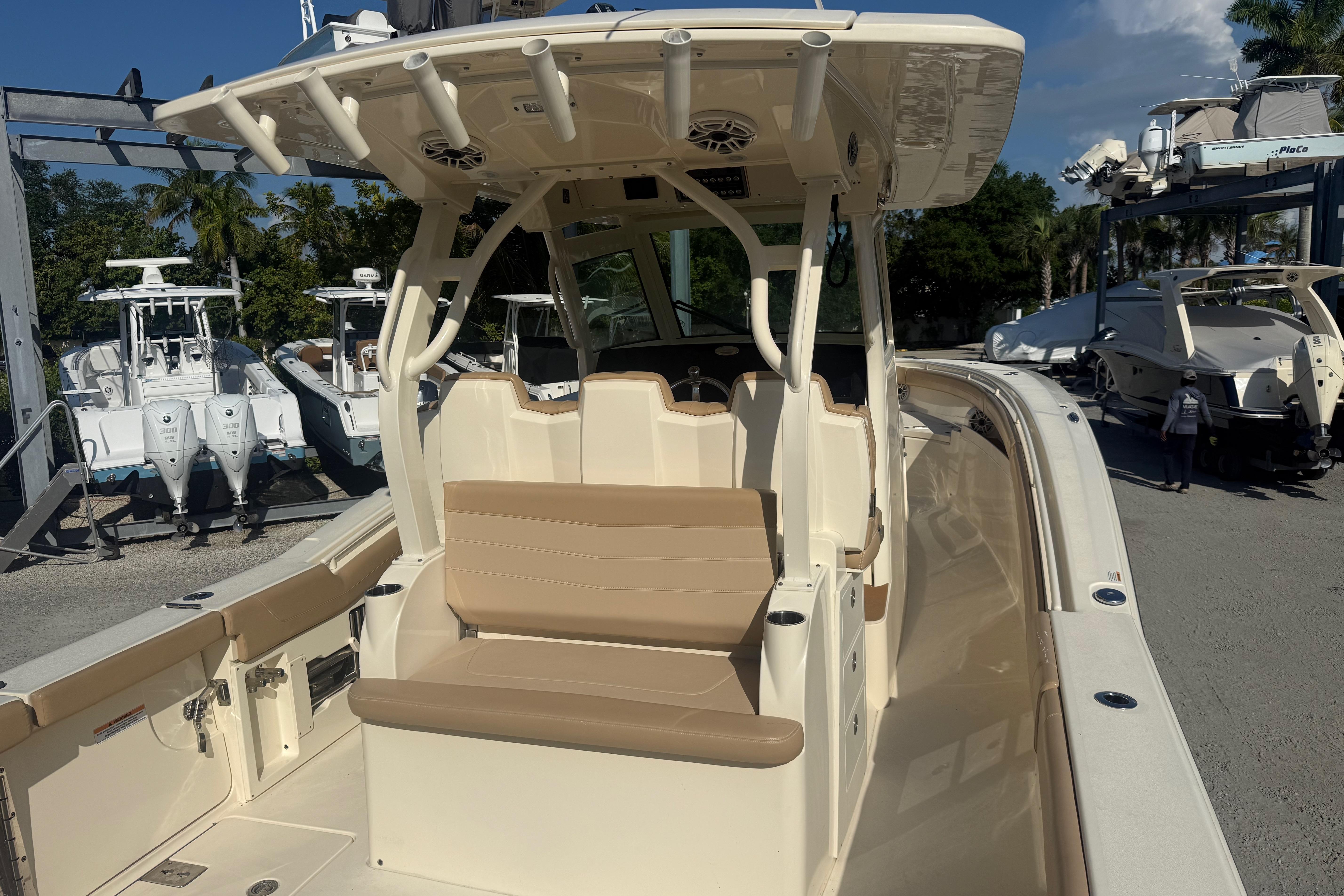 2022 Scout 355 LXF boat with beige seating and T-top, docked outdoors.