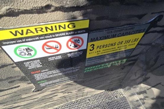 Warning labels on a 2026 Havoc 1553 VJST boat, indicating maximum capacity and safety instructions.