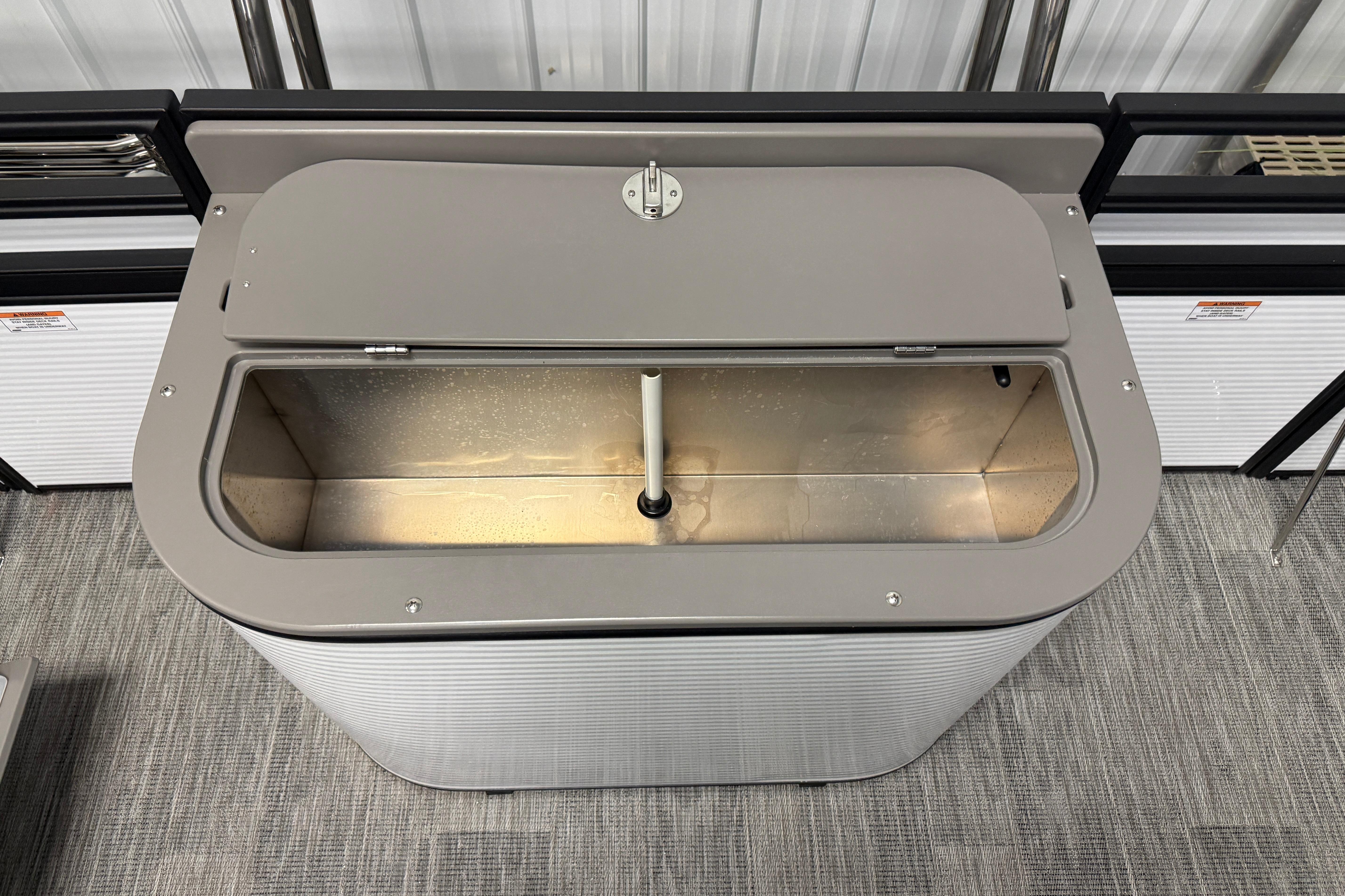 Open storage compartment in 2026 Qwest M-Class 22 Pro Sport boat, showcasing interior design.