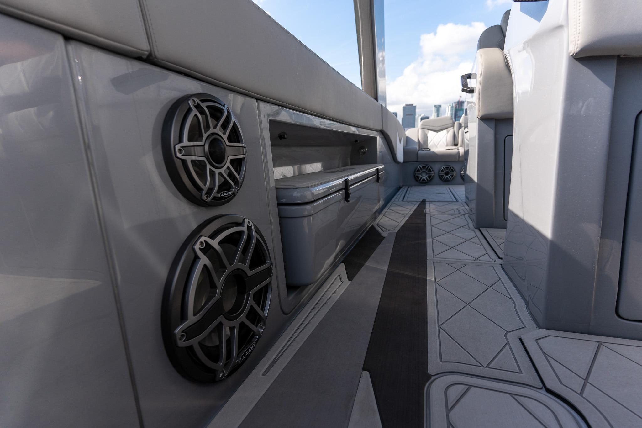 Interior view of 2026 Deep Impact 499 Sport boat, featuring sleek design and modern speakers.