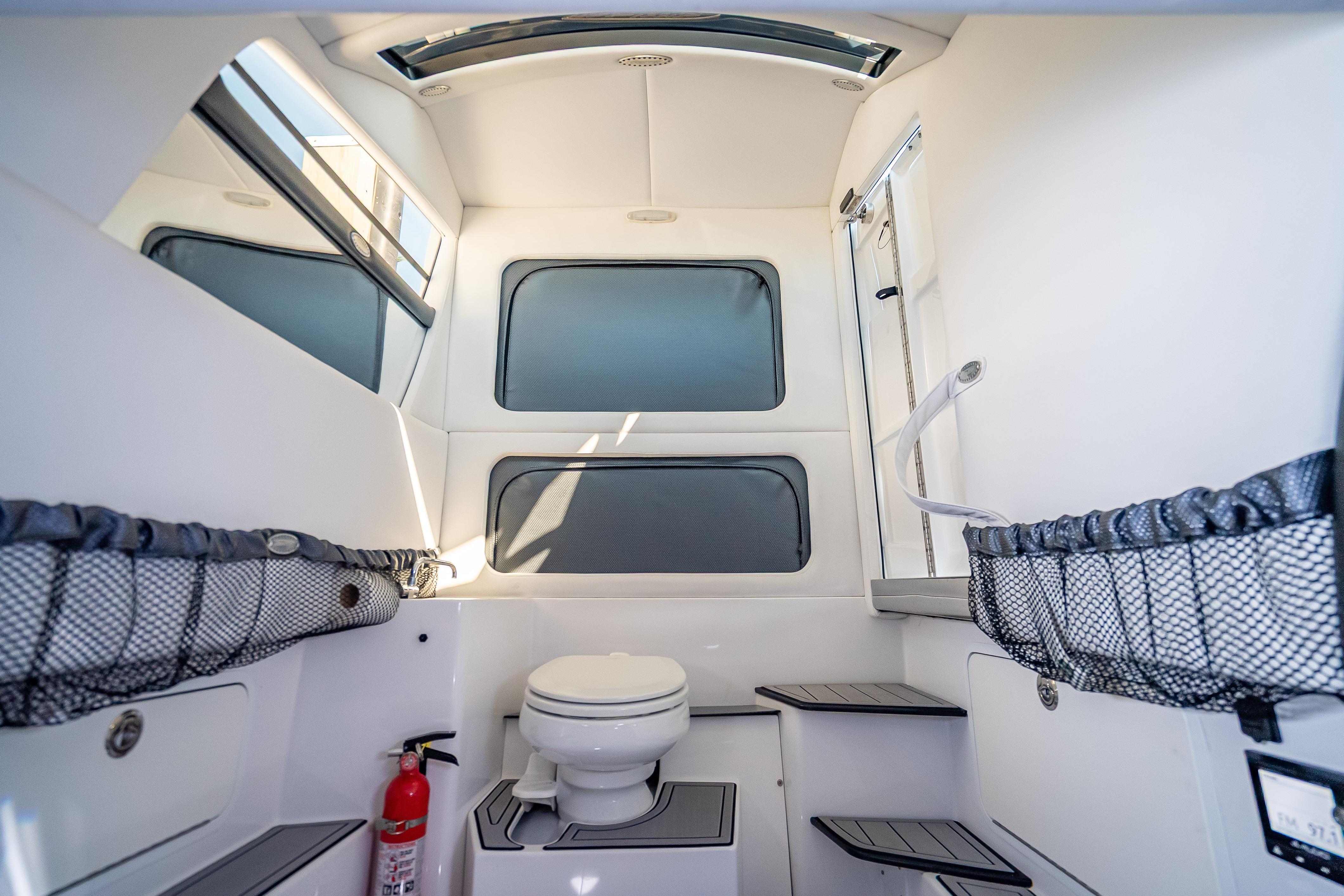 Interior of 2018 Nor-Tech 390 Sport Center Console boat with toilet and storage.