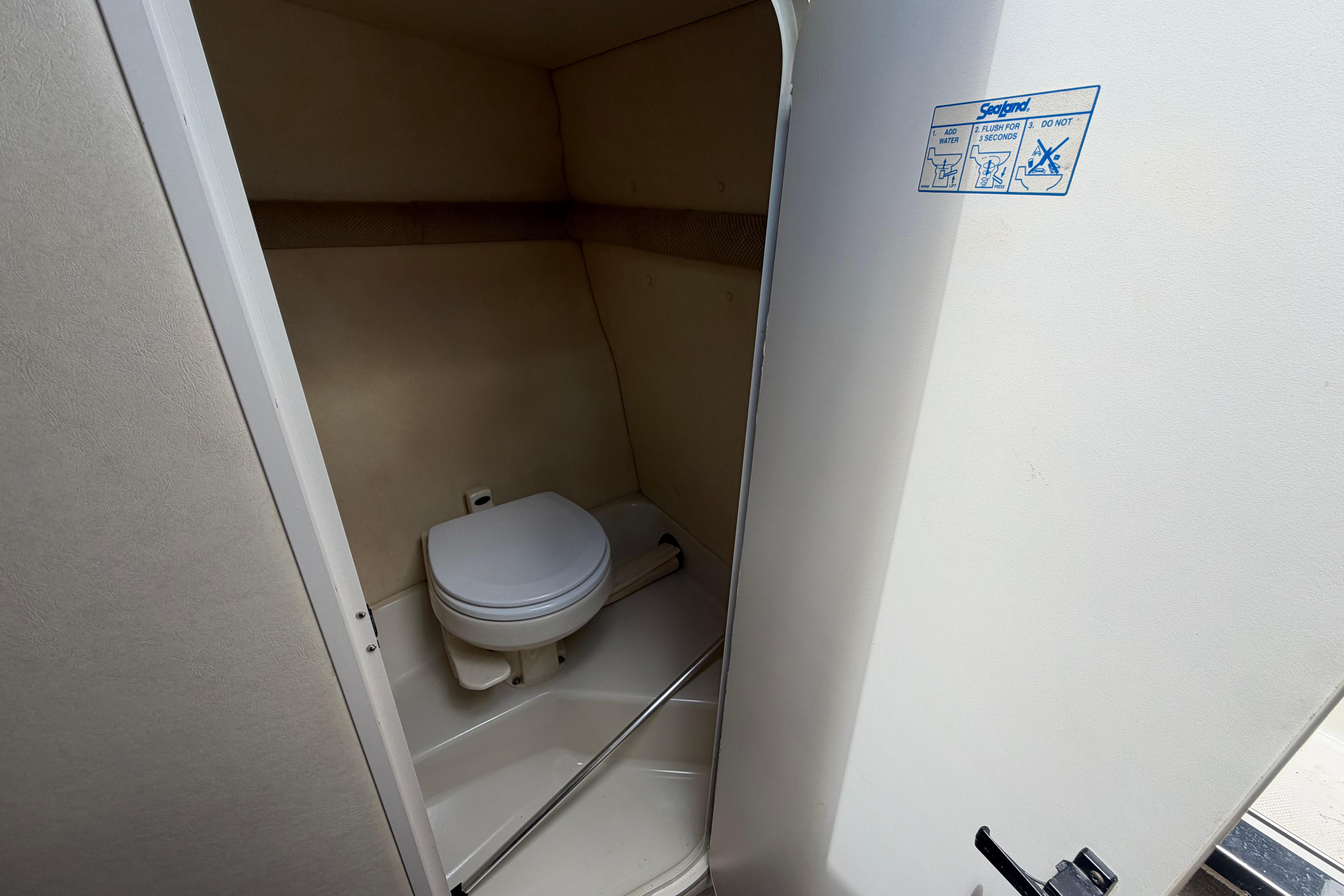 2006 Sea Ray 250 Amberjack boat bathroom interior with toilet and instructions.