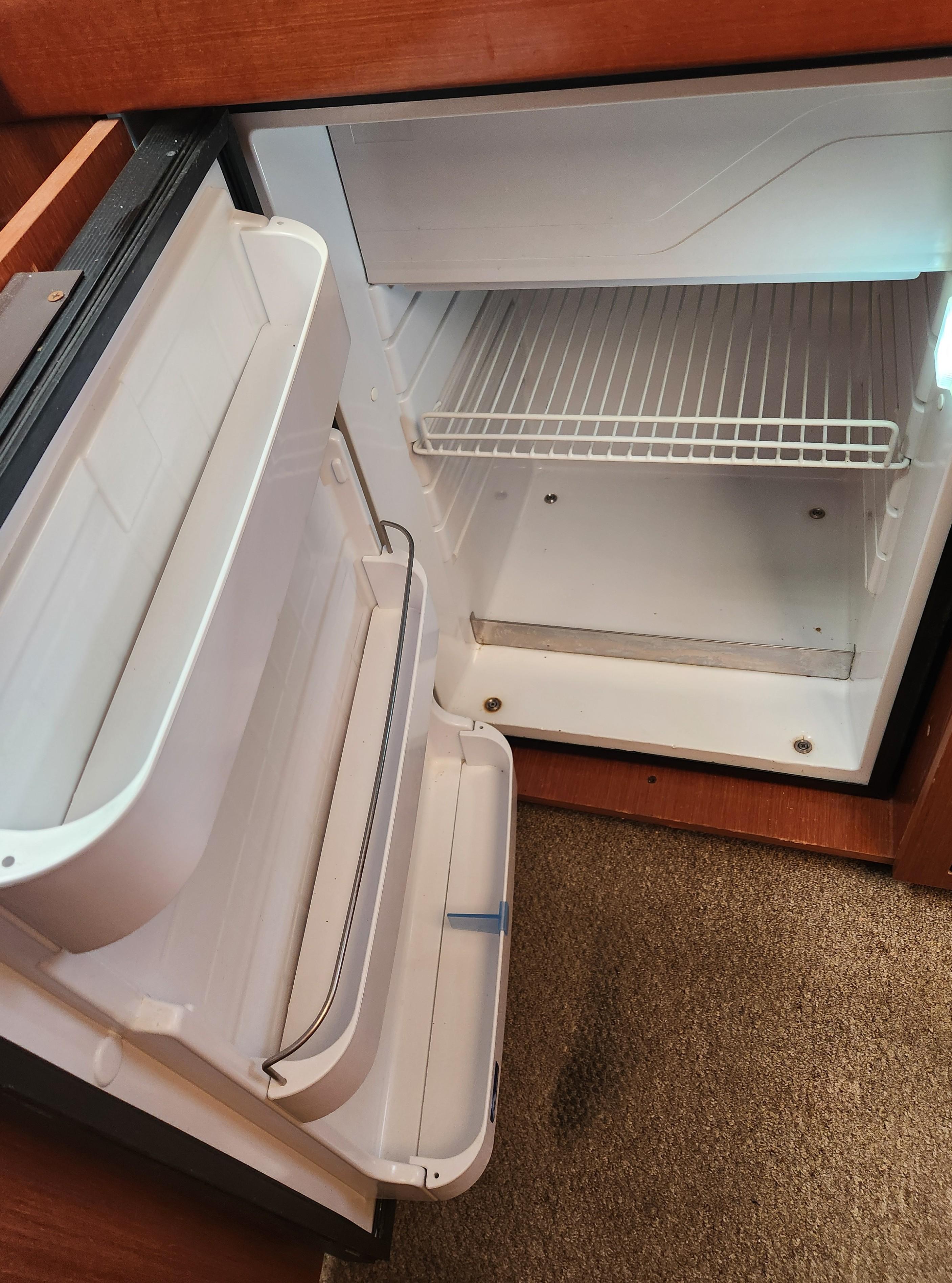 Open refrigerator inside 2012 Beneteau Oceanis 50 yacht, showing empty shelves and door compartments.
