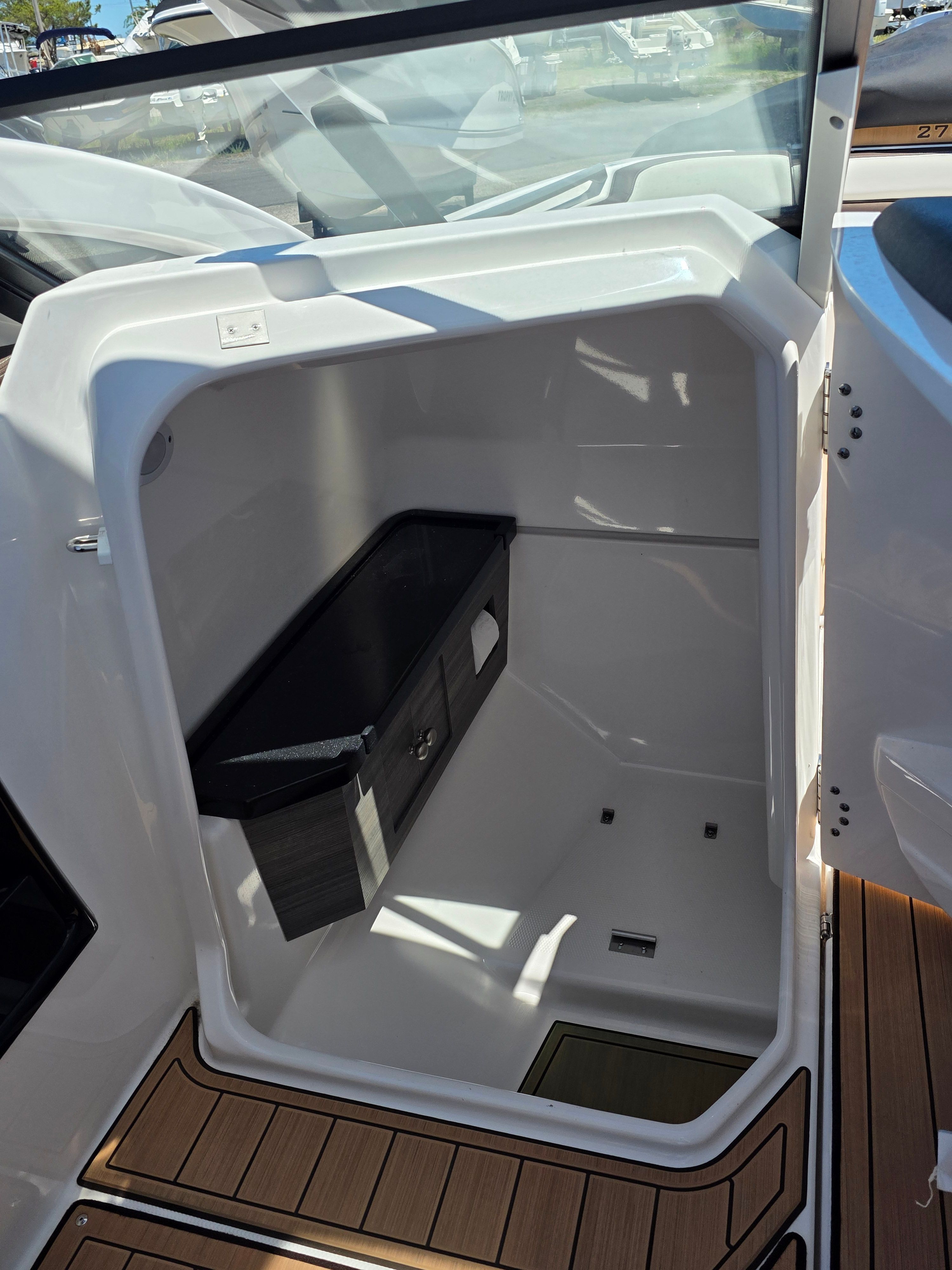 The interior of a 2023 Yamaha Boats sd275 features an open storage area with wood flooring.