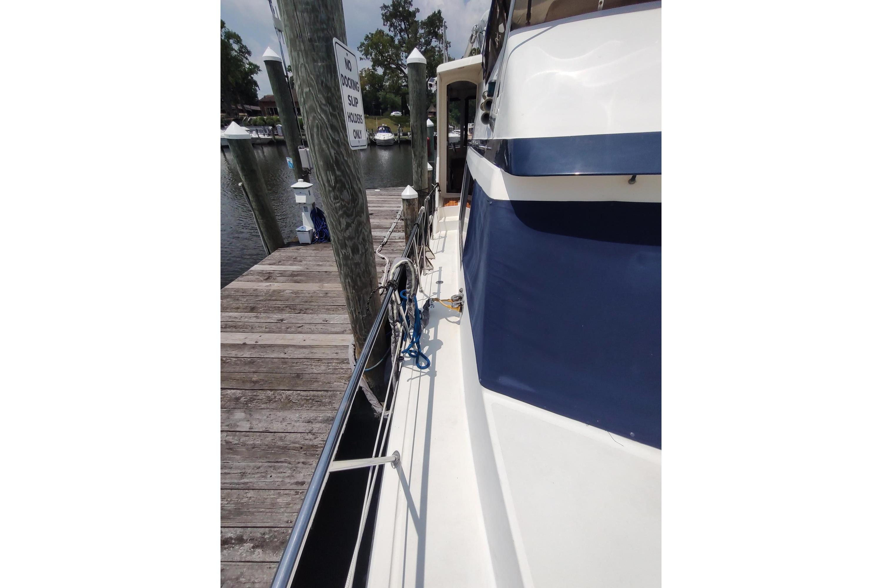 1989 Hyatt Double Cabin Motoryacht docked at marina, side view with wooden pier.