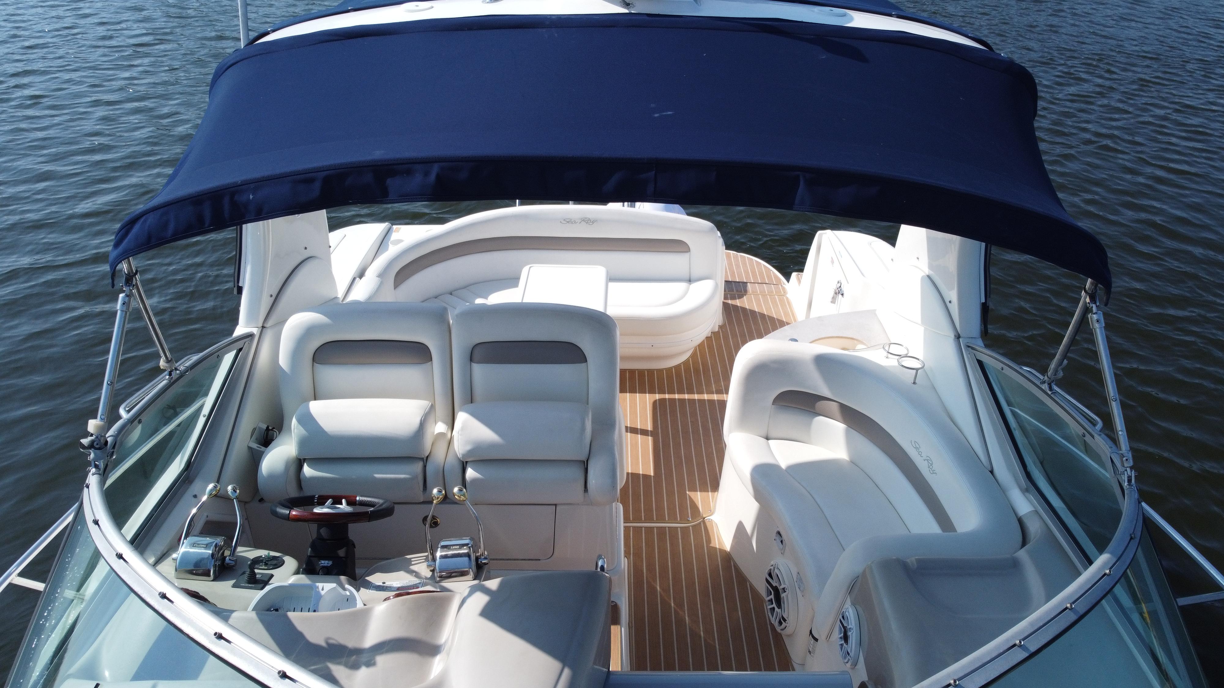 2004 Sea Ray 320 Sundancer boat interior with seating and canopy on water.
