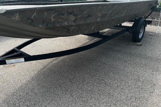 2026 Tracker Grizzly 1754 Utility boat on trailer, parked on pavement.