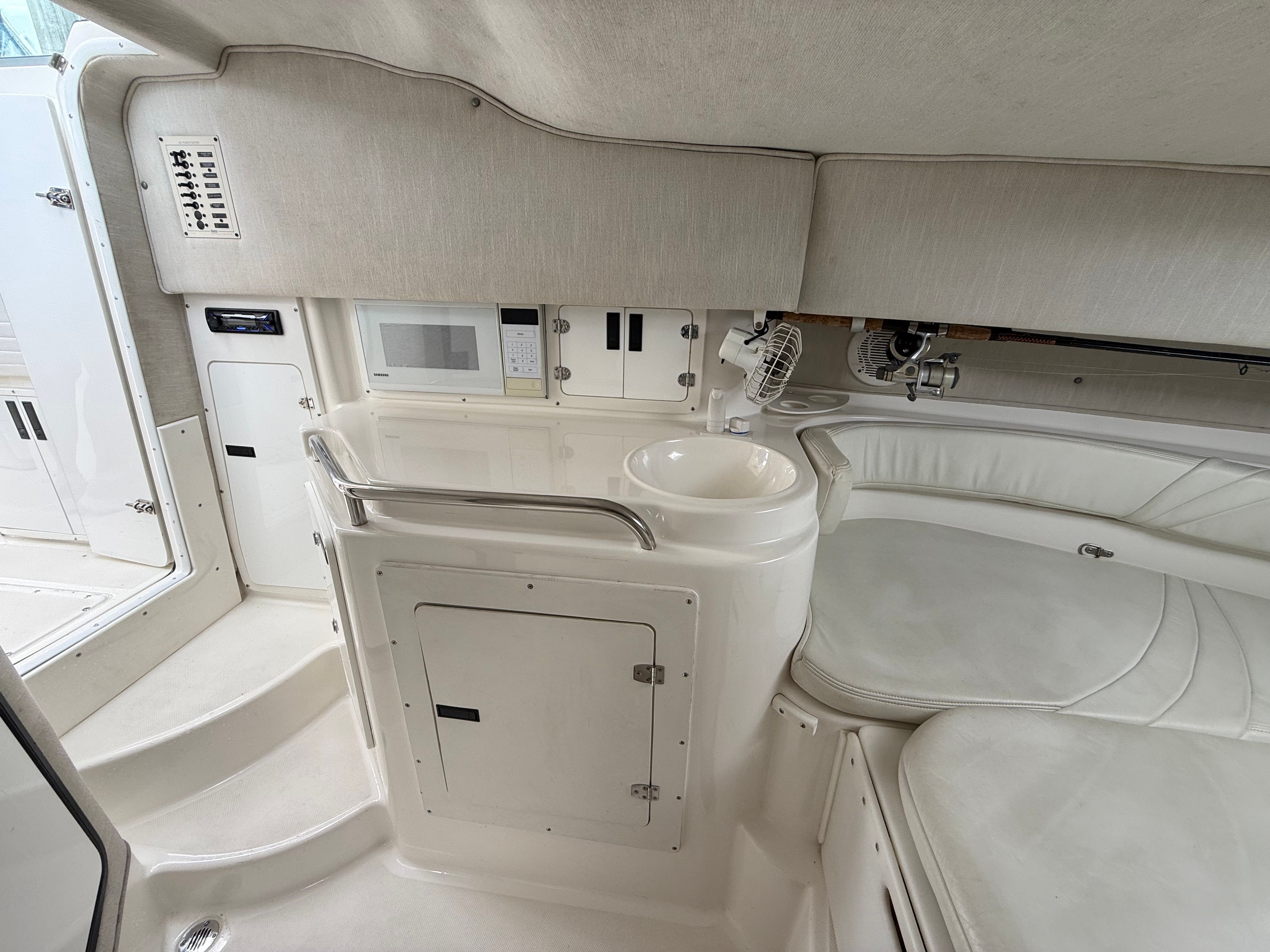 Interior of a 1999 Fountain 32 Sport Fish Cruiser with seating and sink.