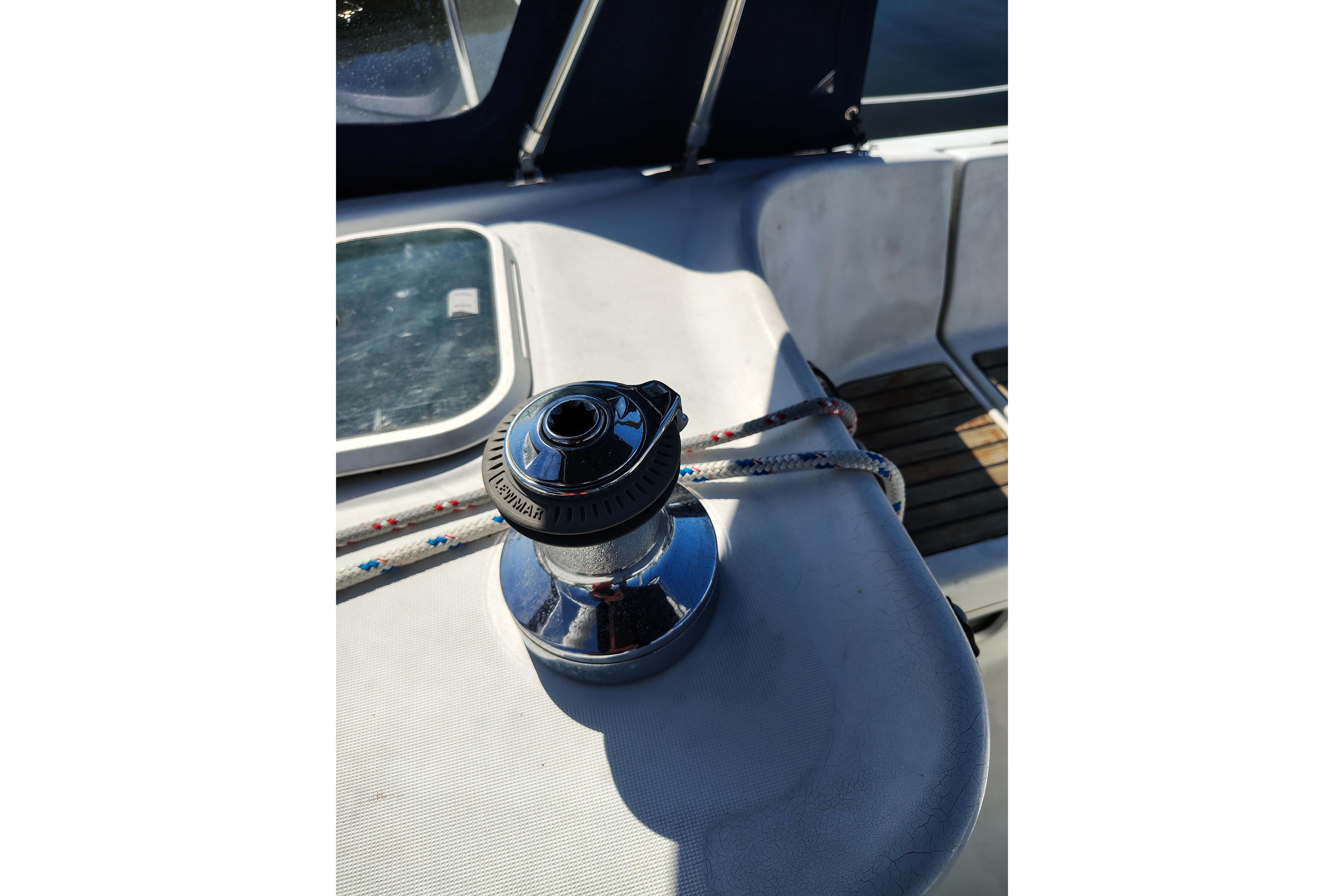 Winch on 2001 Beneteau Oceanis 411 sailboat deck, with ropes and hatch visible.