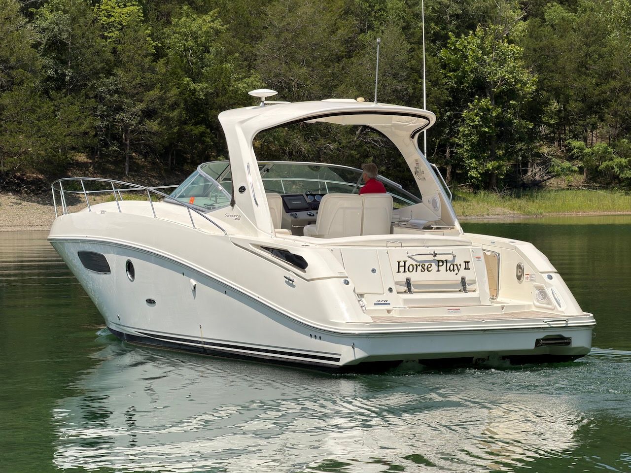 A 2011 Sea Ray Sundancer 370 on a calm lake.