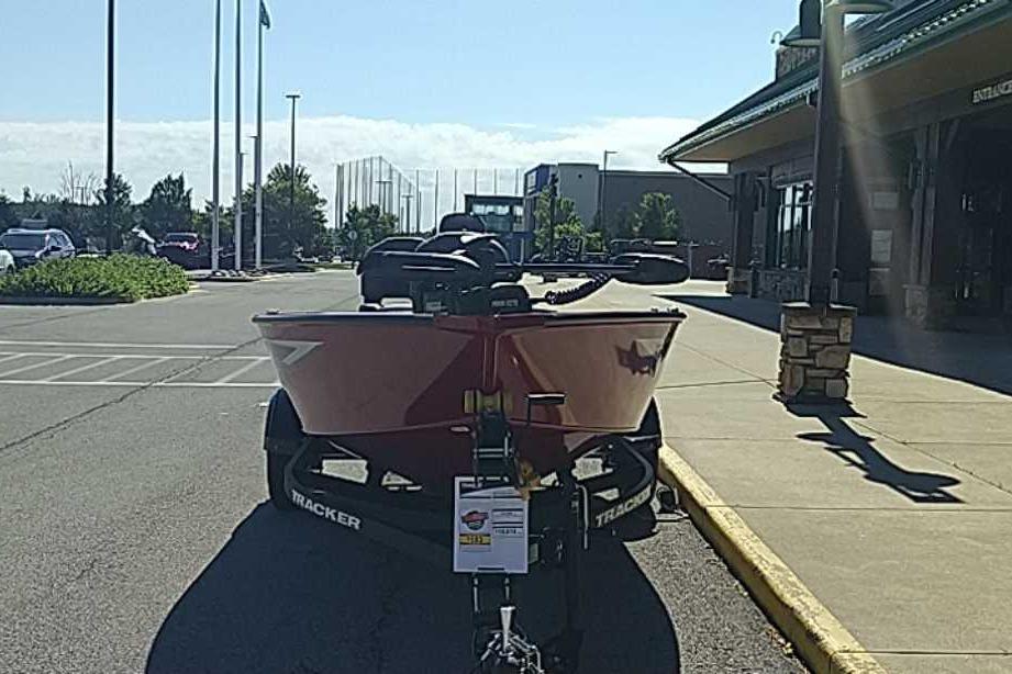 2026 Tracker Super Guide V-16 T boat on trailer in parking lot.