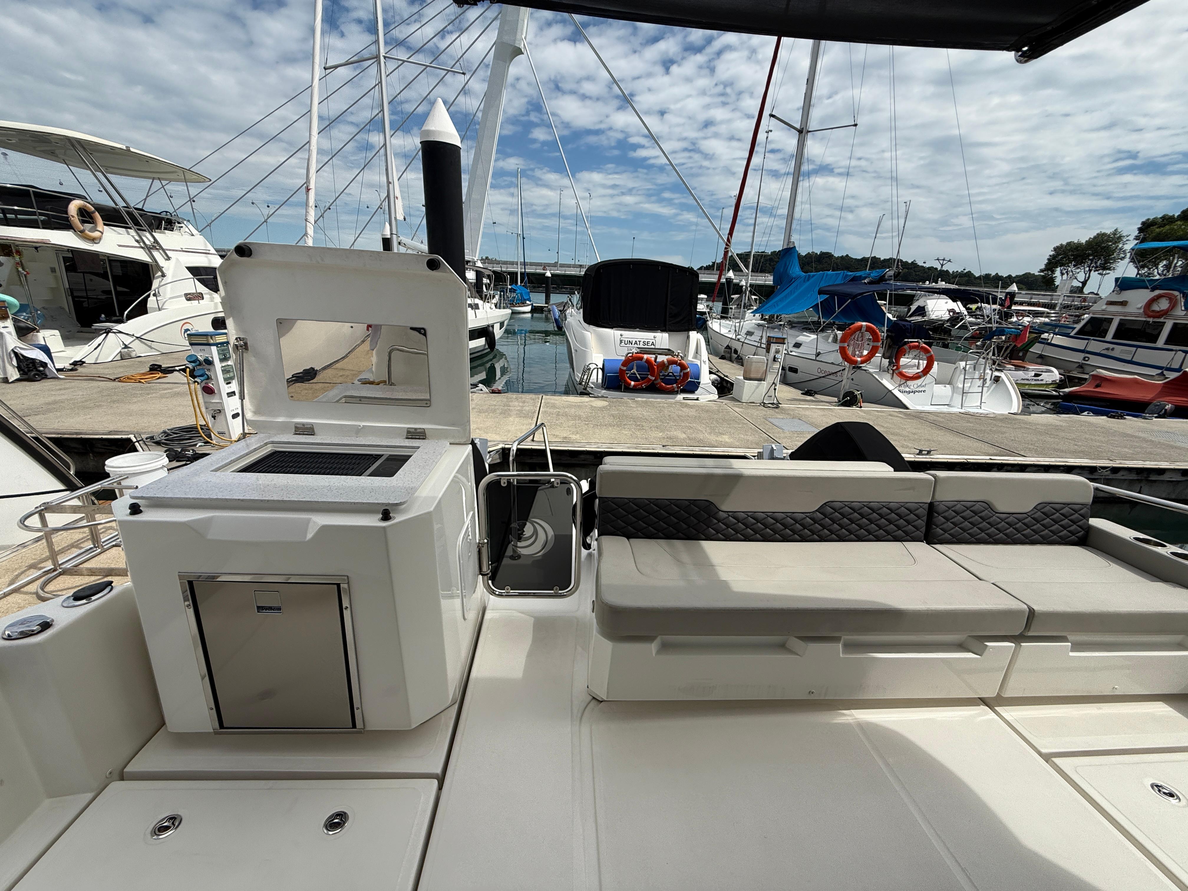 Aquila 36 Sport 2022 yacht interior with seating and grill at marina.
