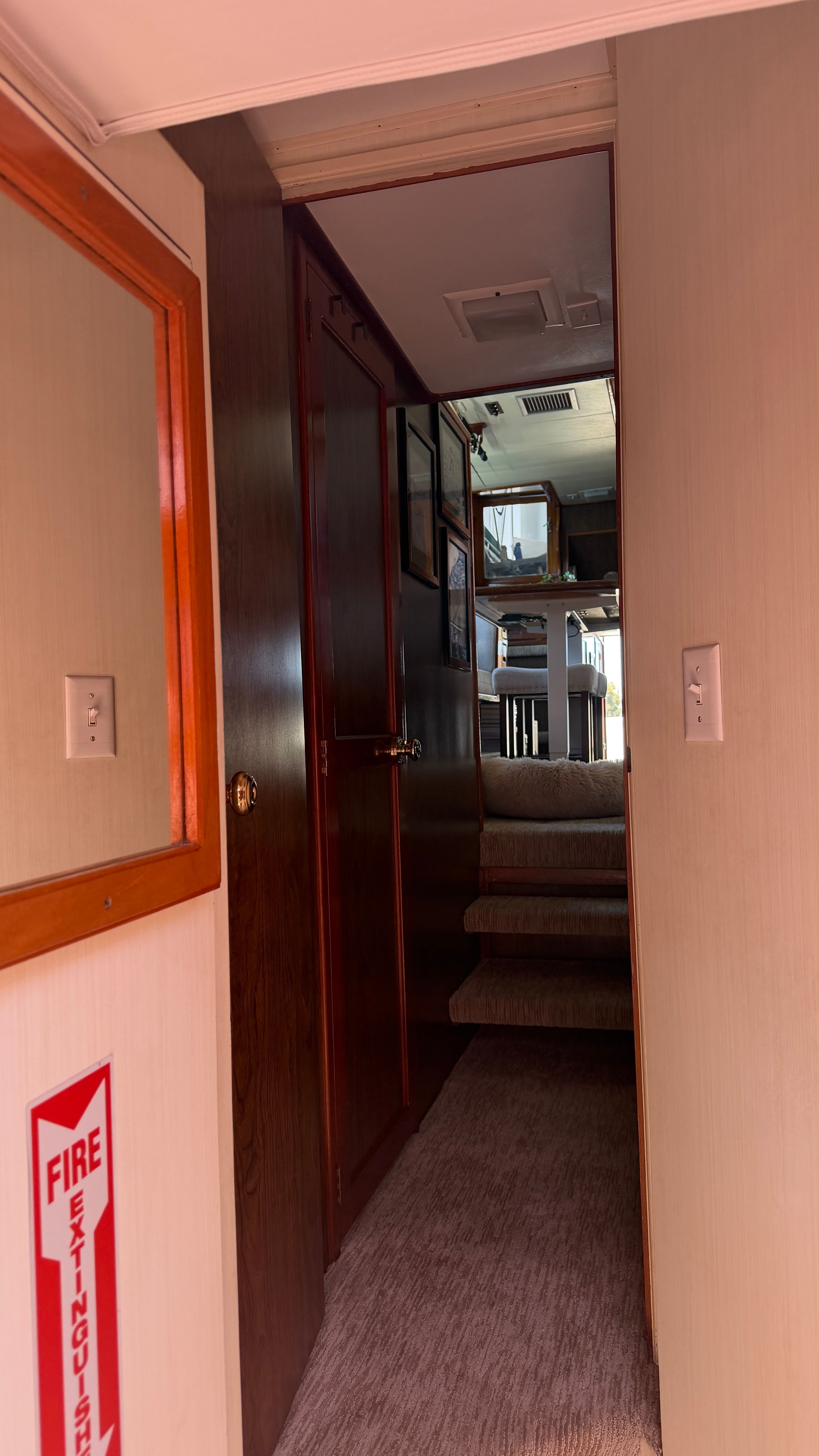 Interior of a 1966 Drake Yachtfisher with stairs and fire extinguisher.
