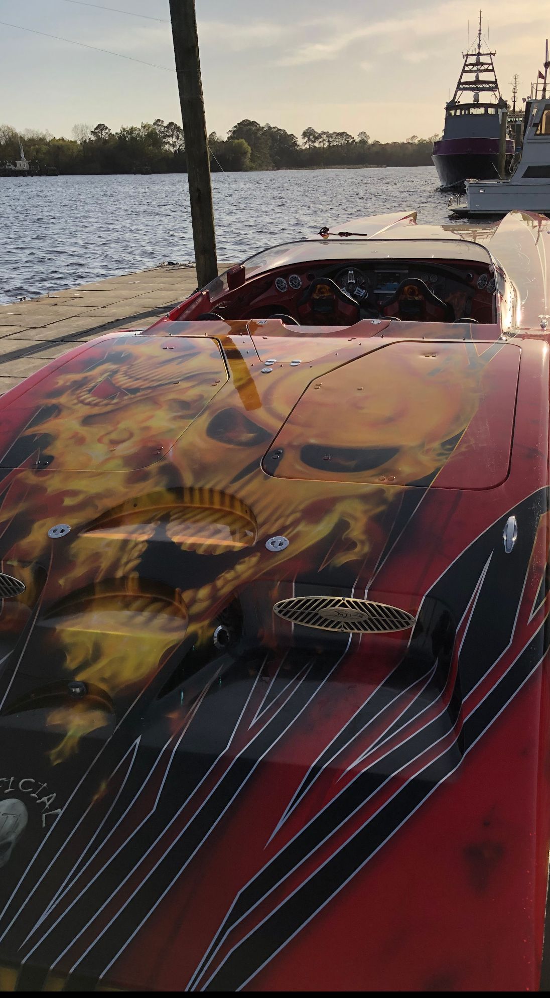 A 2010 MTI CAT with striking flame design, docked with water in the background.
