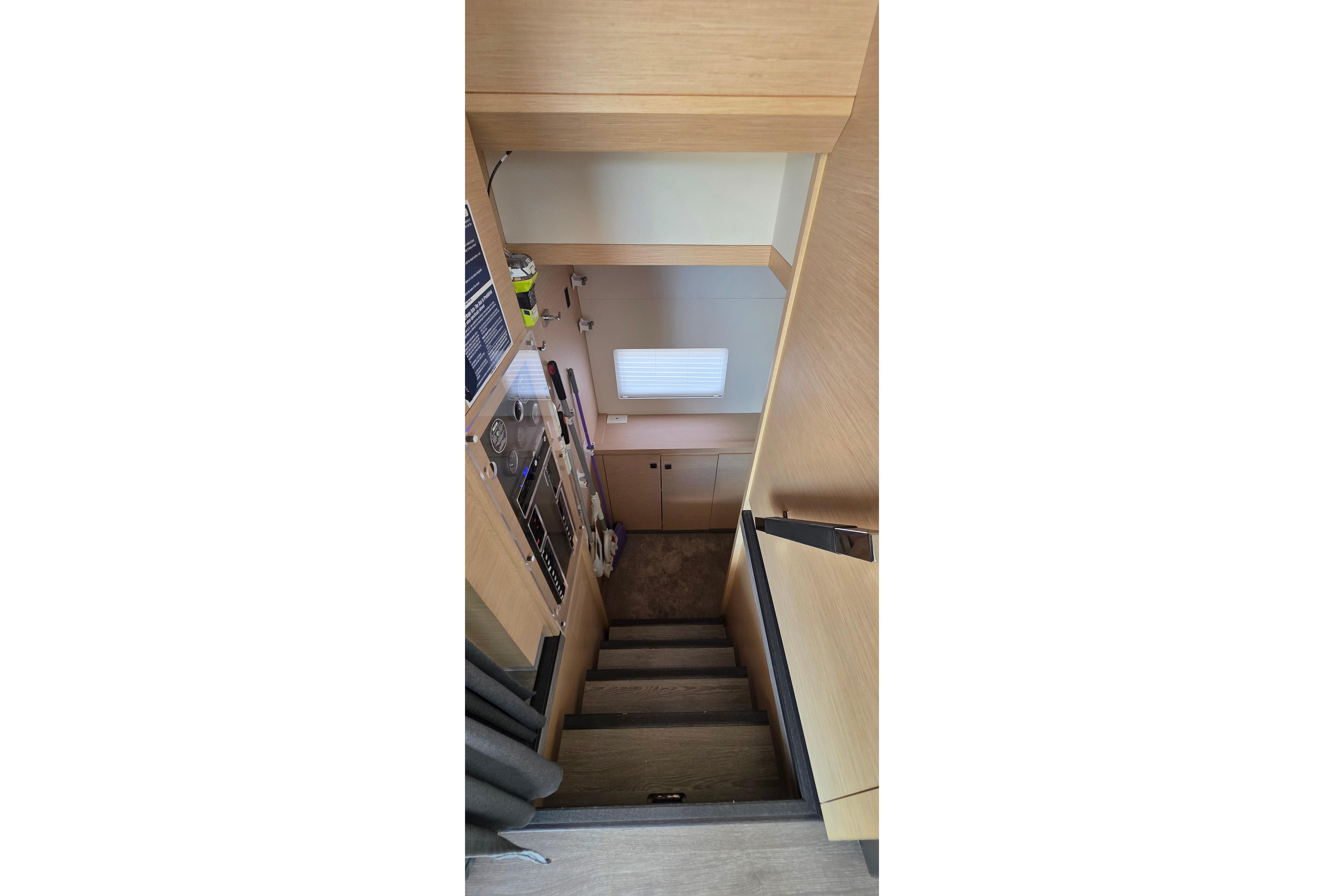 Interior stairs of 2018 Fountaine Pajot Motor Yacht 44, featuring modern wood design.