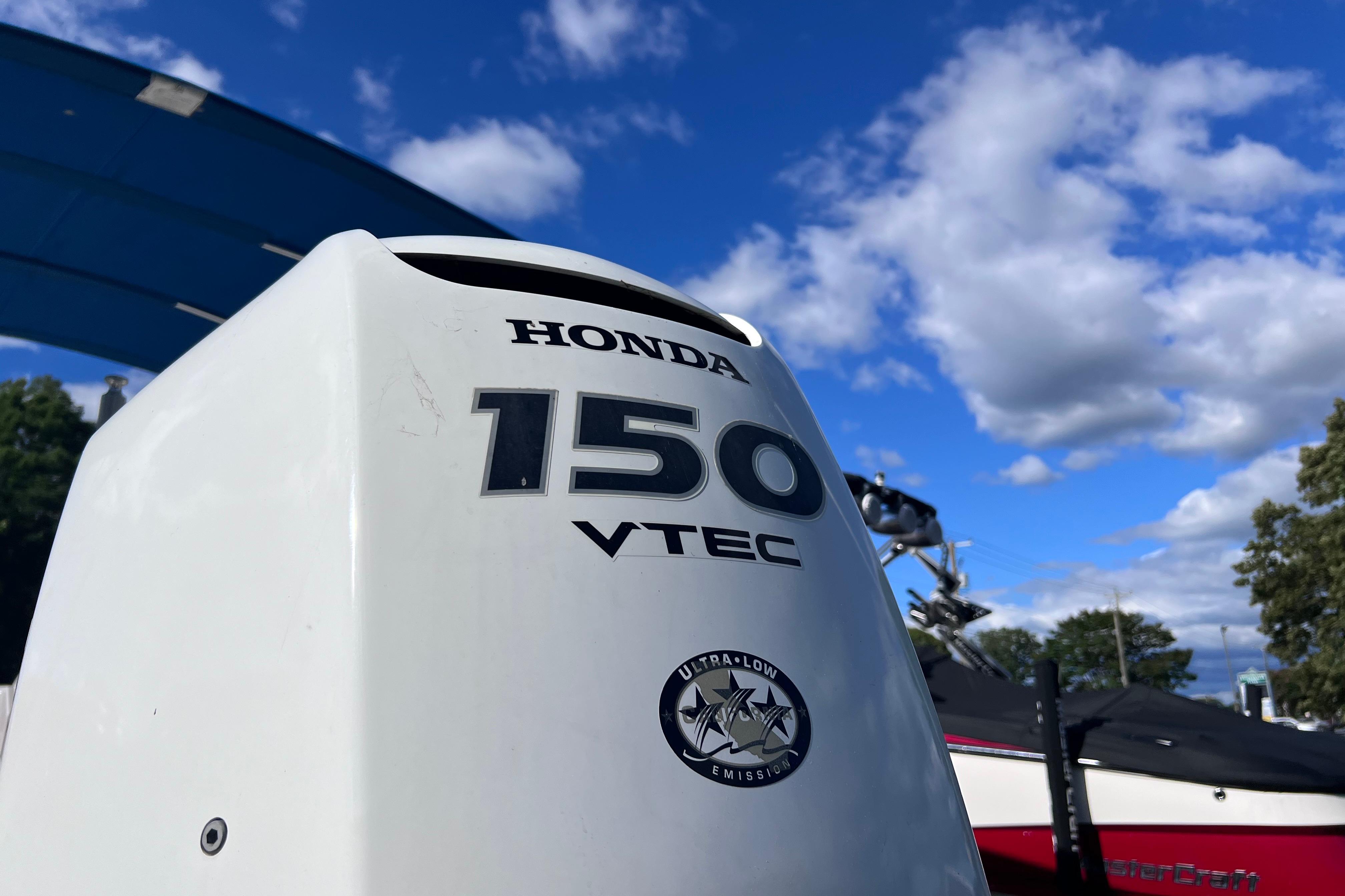 Honda 150 VTEC outboard motor on a 2021 Starcraft SVX 211 OB boat under blue sky.