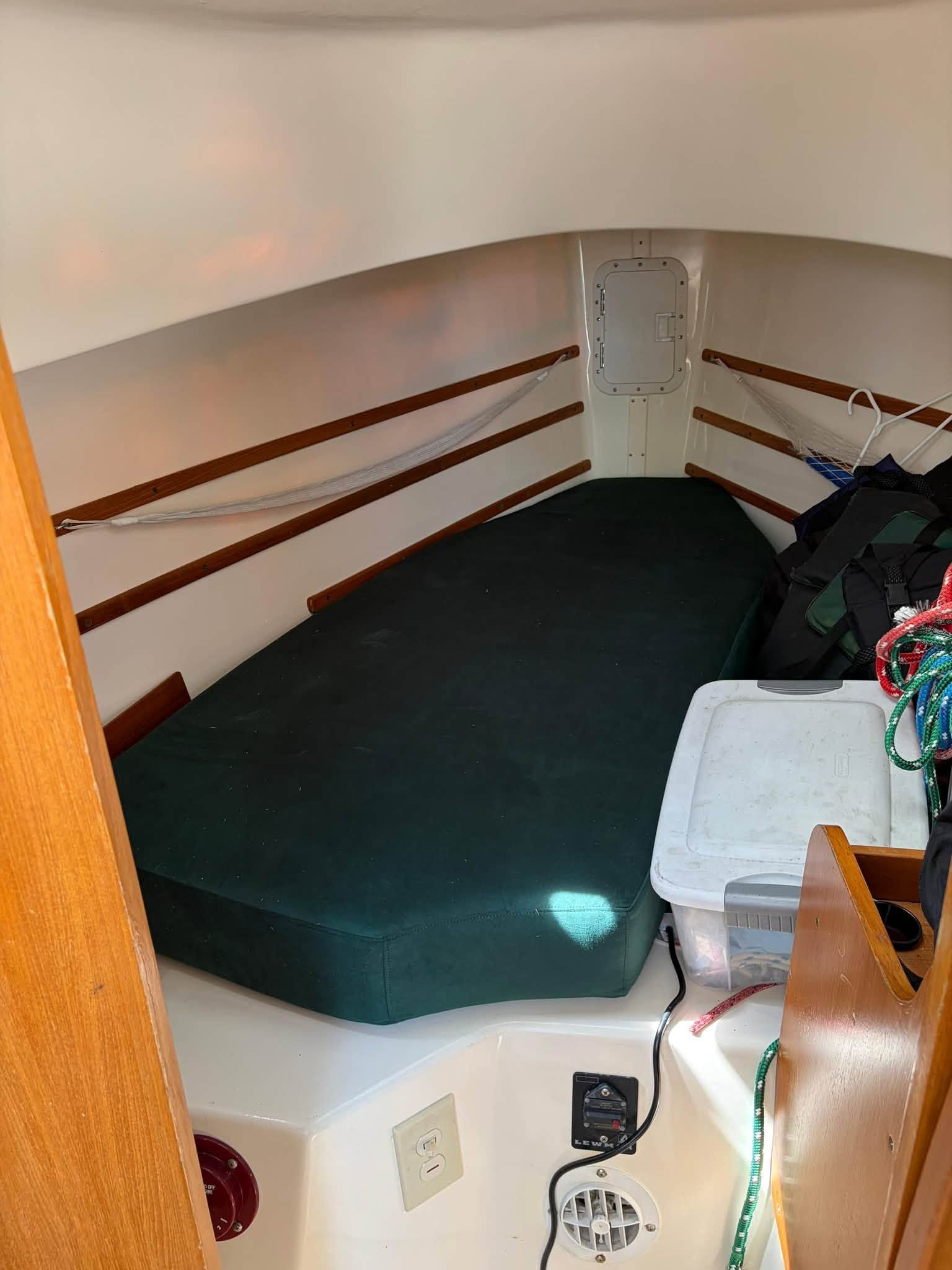 Interior of a 2003 Seaward 25 with green cushions and storage space.