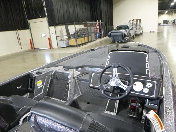 2025 Ranger Z520 boat interior with steering wheel, dashboard, and seating in a warehouse setting.