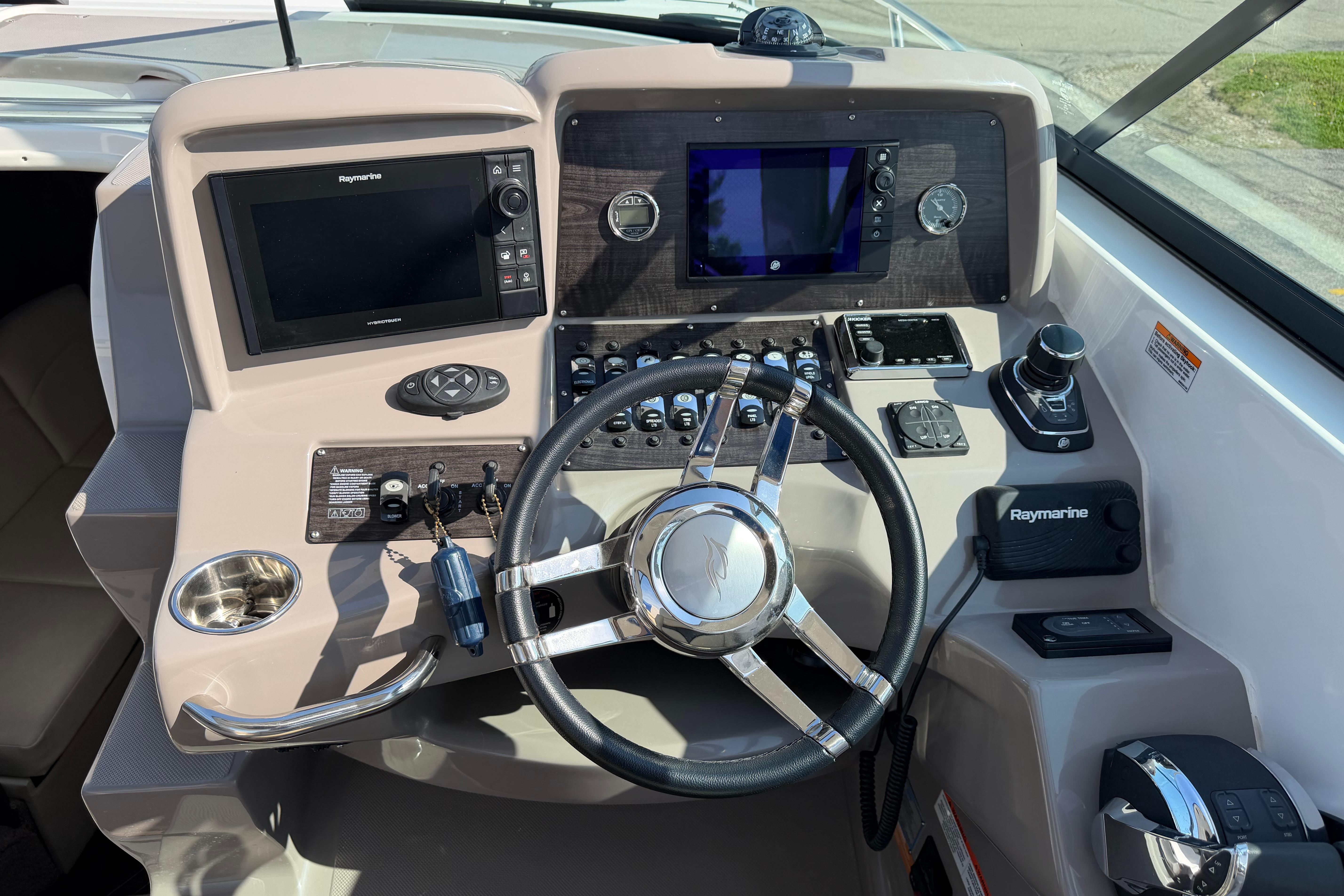2019 Rinker EX 320 boat dashboard with steering wheel and navigation controls.