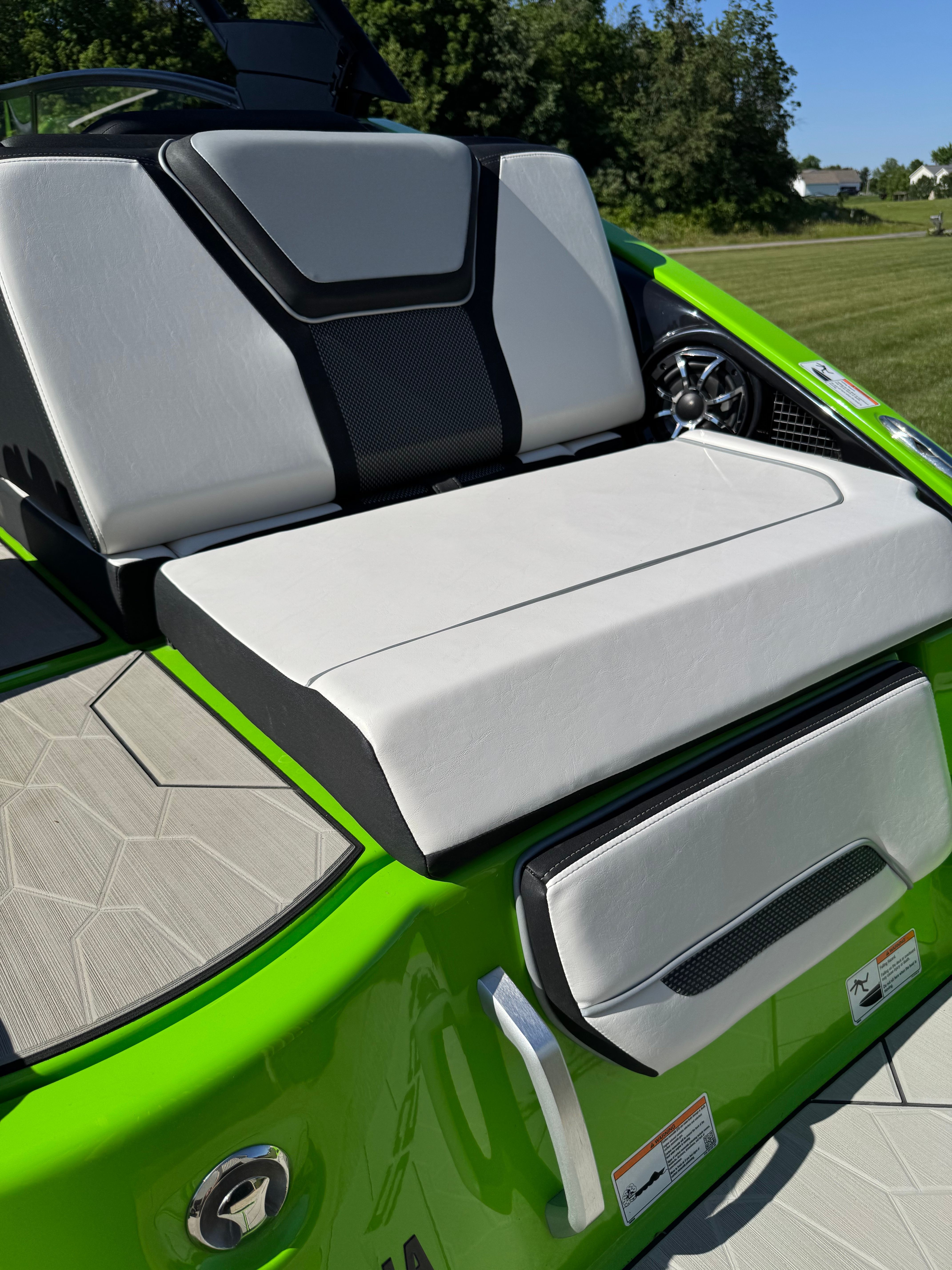 Yamaha Boats 255XD 2022: White and black seating on a green boat.
