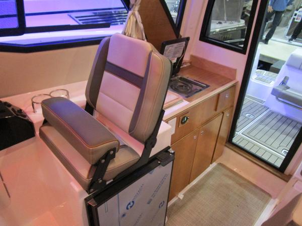 Interior of 2025 Cutwater C-248 Coupe featuring helm seat and compact kitchenette.