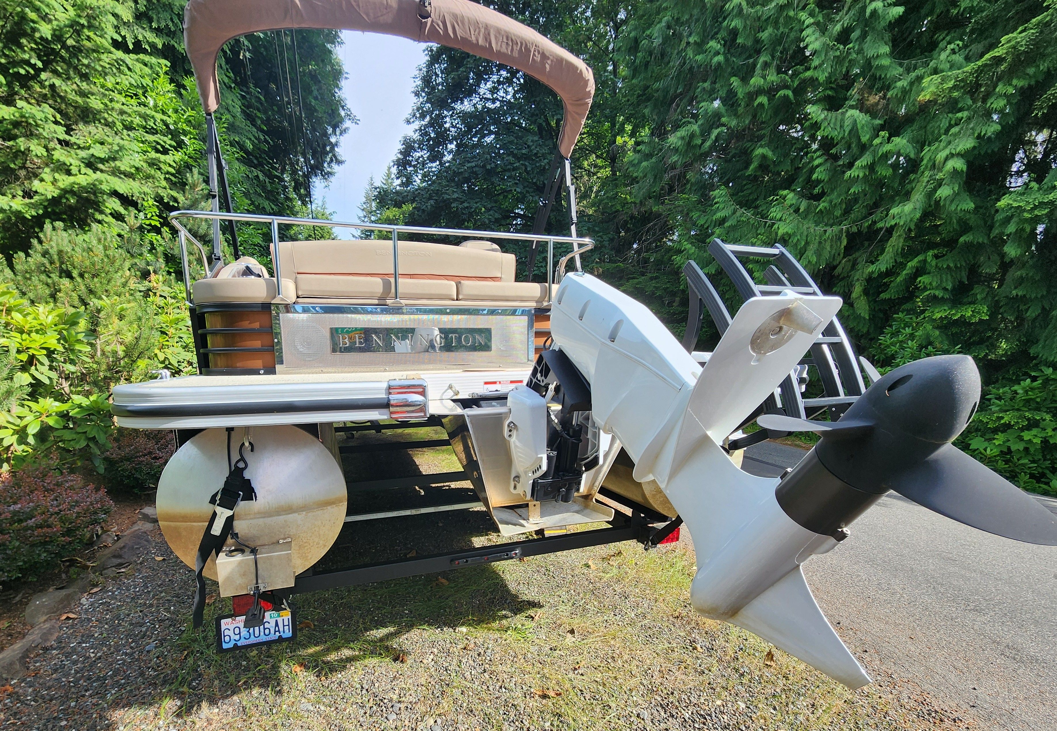 Bennington 22 LSB 2023 on a trailer, surrounded by trees.