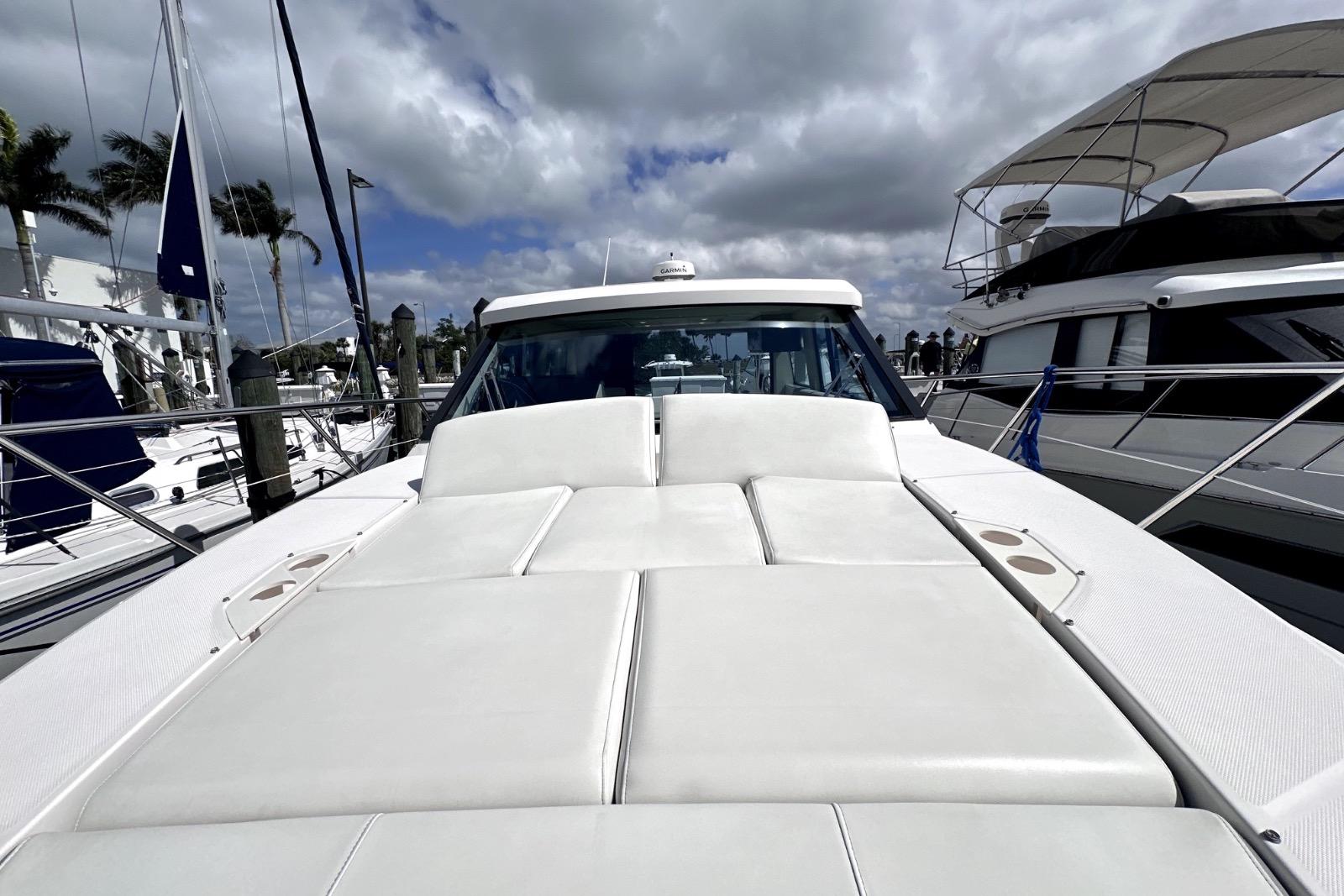 2021 Regal 38 XO yacht with spacious sunbathing deck under cloudy sky.
