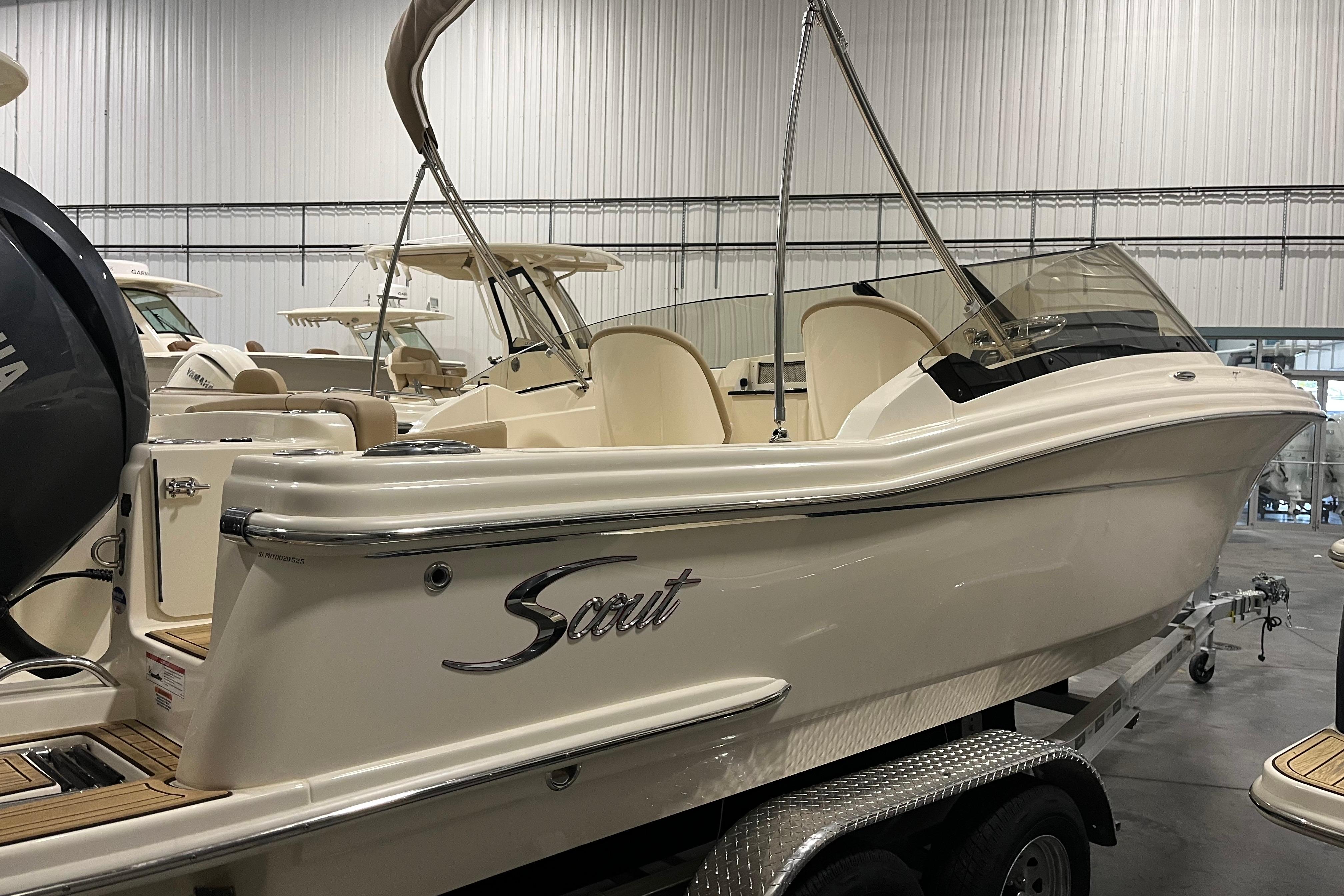 2025 Scout 215 Dorado boat on trailer in indoor showroom.