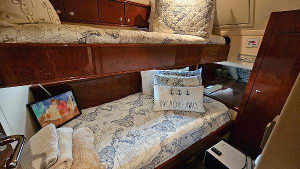 Cozy cabin interior of 2005 Neptunus 56 Flybridge yacht with nautical-themed bedding.