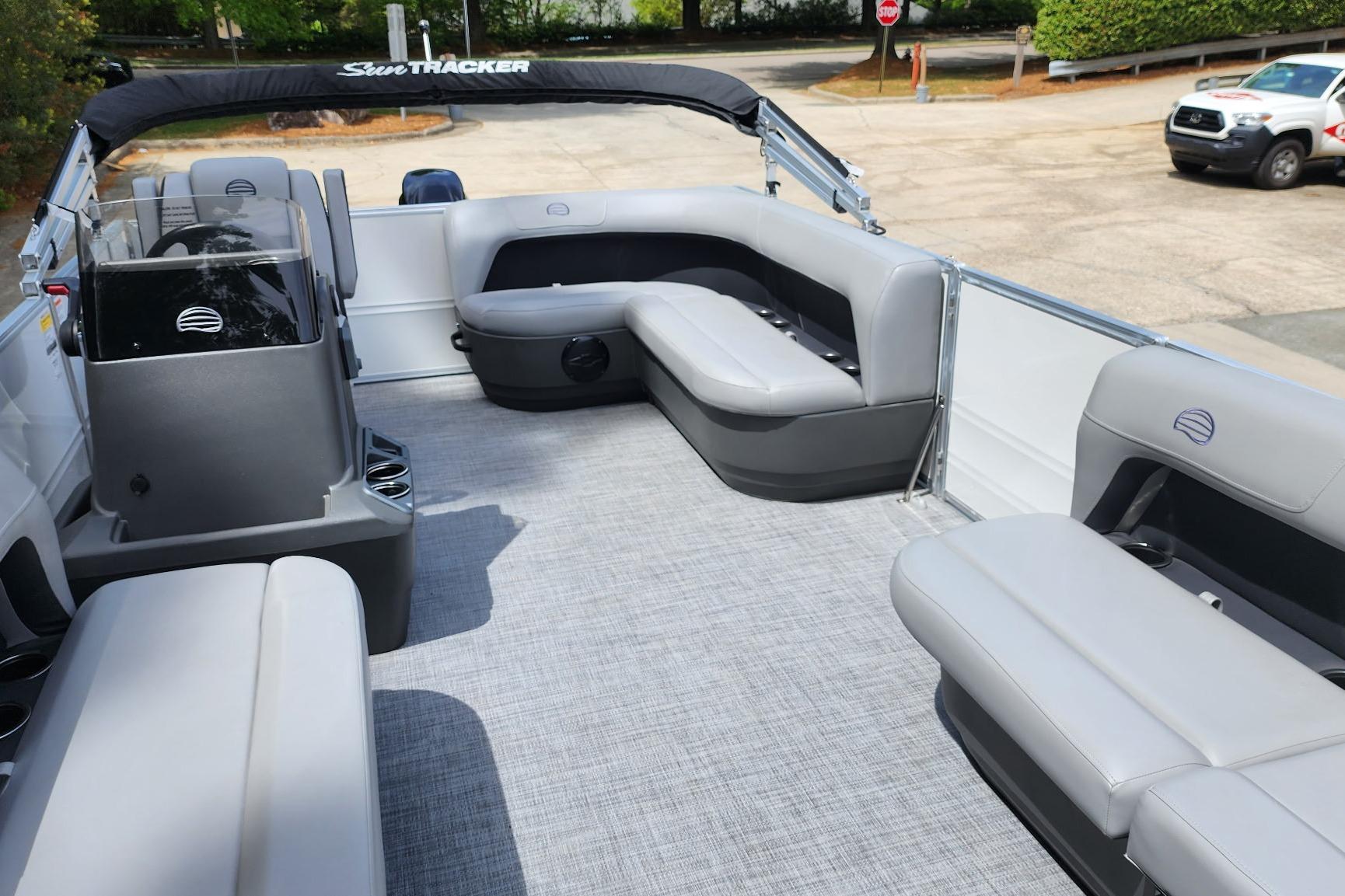 2026 Sun Tracker Party Barge 16 DLX interior with gray seating and helm.