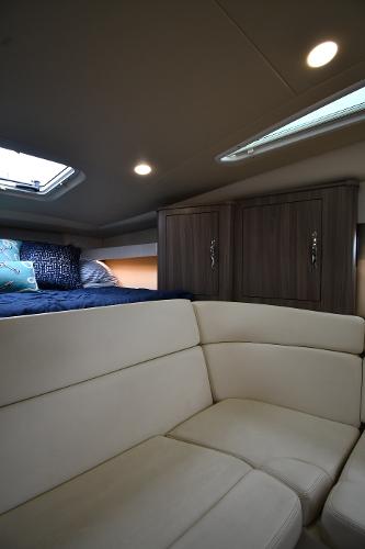 2021 Regal 35 Sport Coupe interior with beige seating and wooden cabinets.