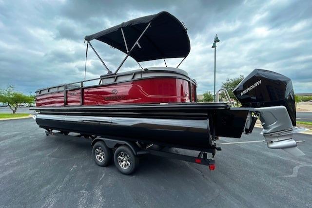 2026 Regency 250 DL pontoon boat with canopy and Mercury outboard motor on trailer.