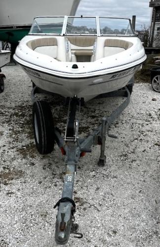 2005 Glastron MX boat on trailer, parked on gravel.
