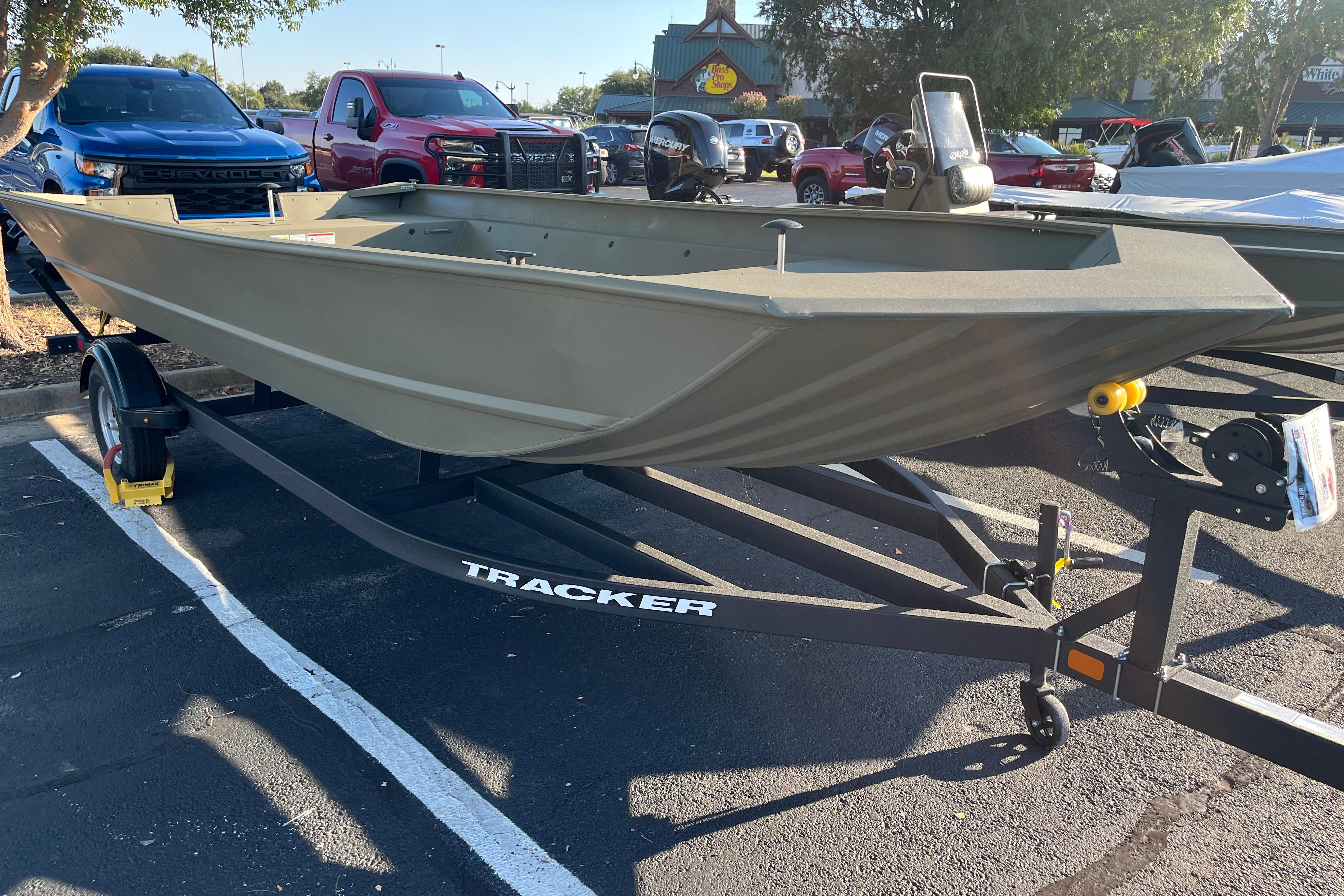 2026 Tracker GRIZZLY 2072 Utility boat on trailer in parking lot.