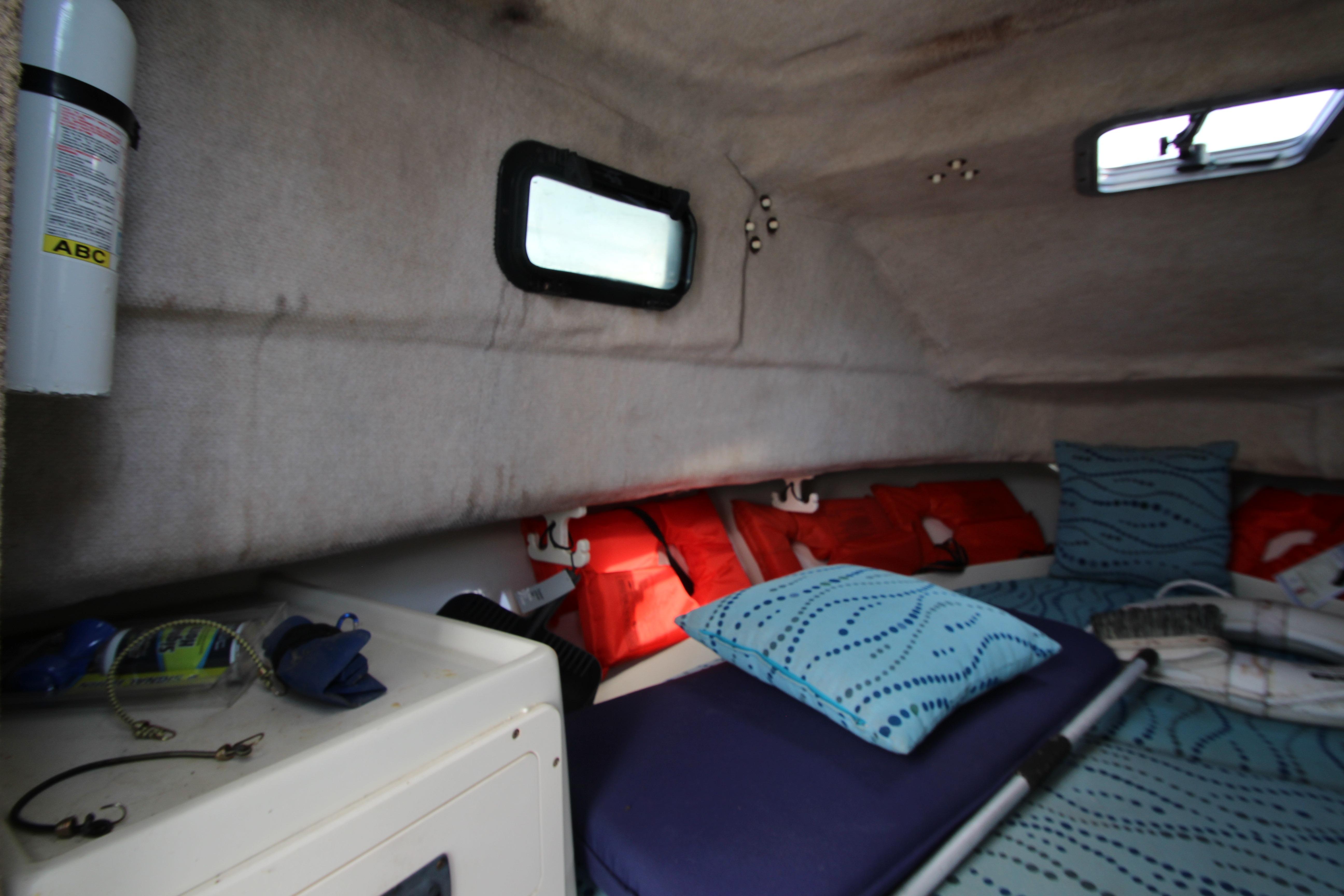 Interior cabin of 2002 Hydra-Sports 230 WA boat with cushions and safety equipment.