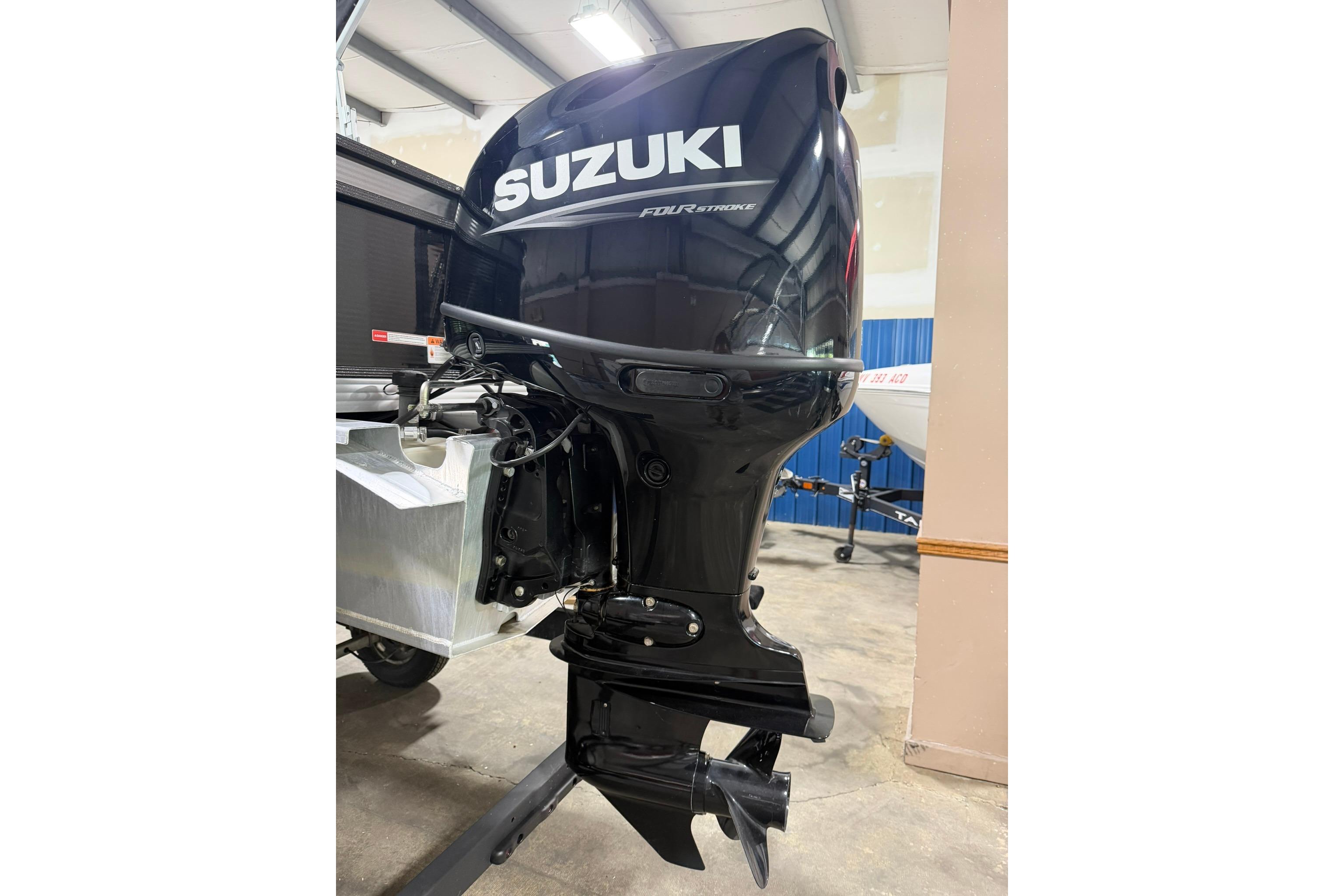 2023 Crest Classic LX 200 with Suzuki outboard motor in a showroom.