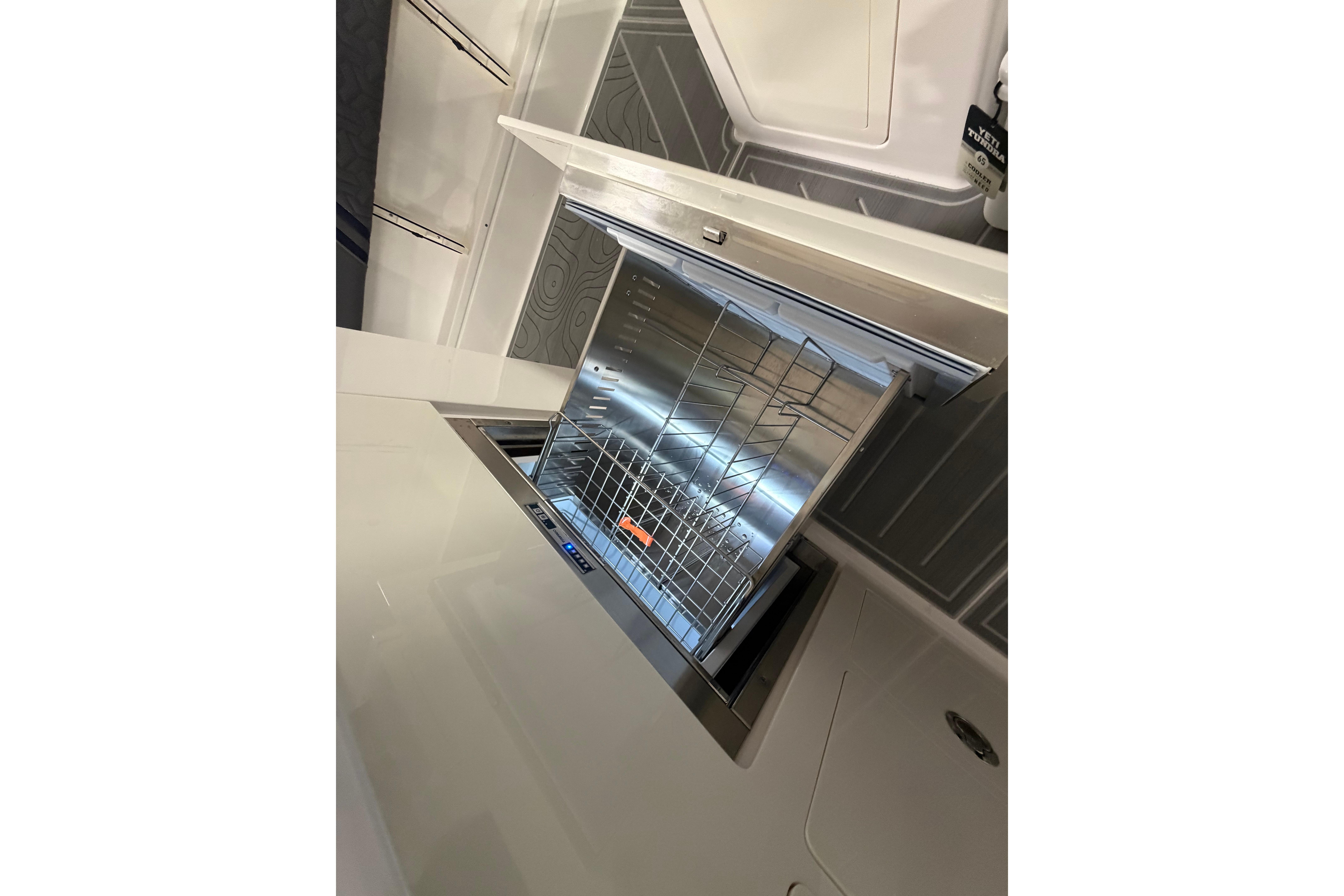 Open dishwasher in the galley of a 2027 Regal 38 Surf boat.