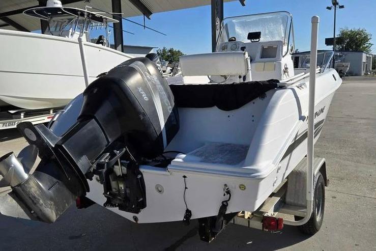 2001 Pro-Line 19 Sport boat with outboard motor on trailer in a marina.
