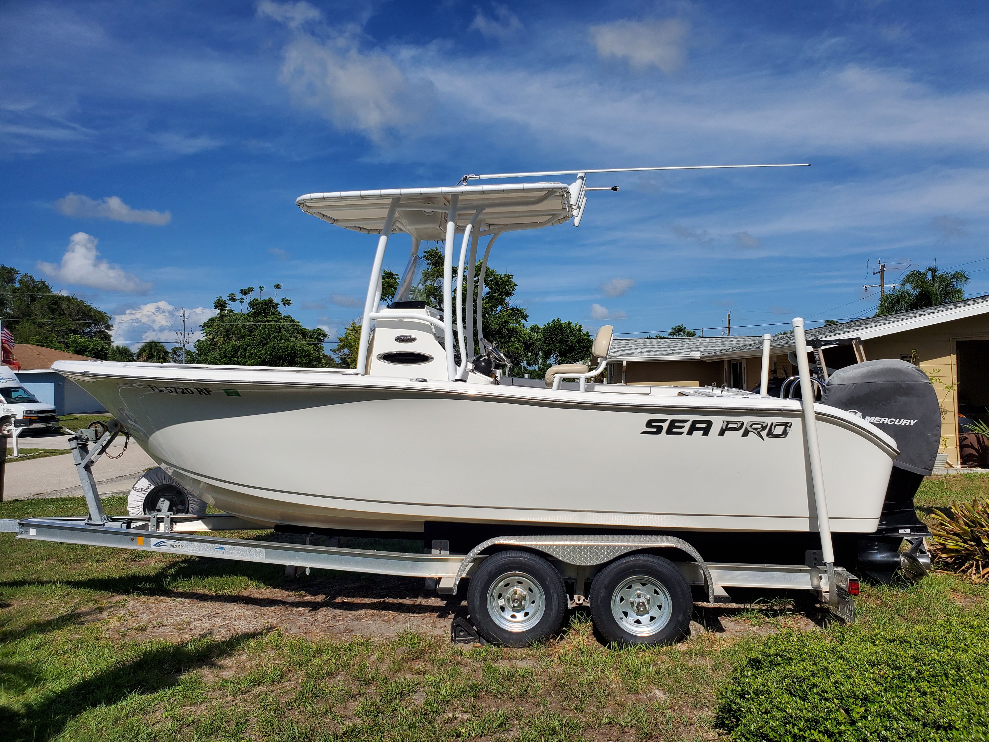 A 2017 Sea Pro 219 Center Console boat on a trailer, parked on a lawn.