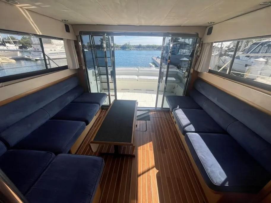 Interior of 1985 Princess Sedan Flybridge yacht with blue seating and wooden flooring.