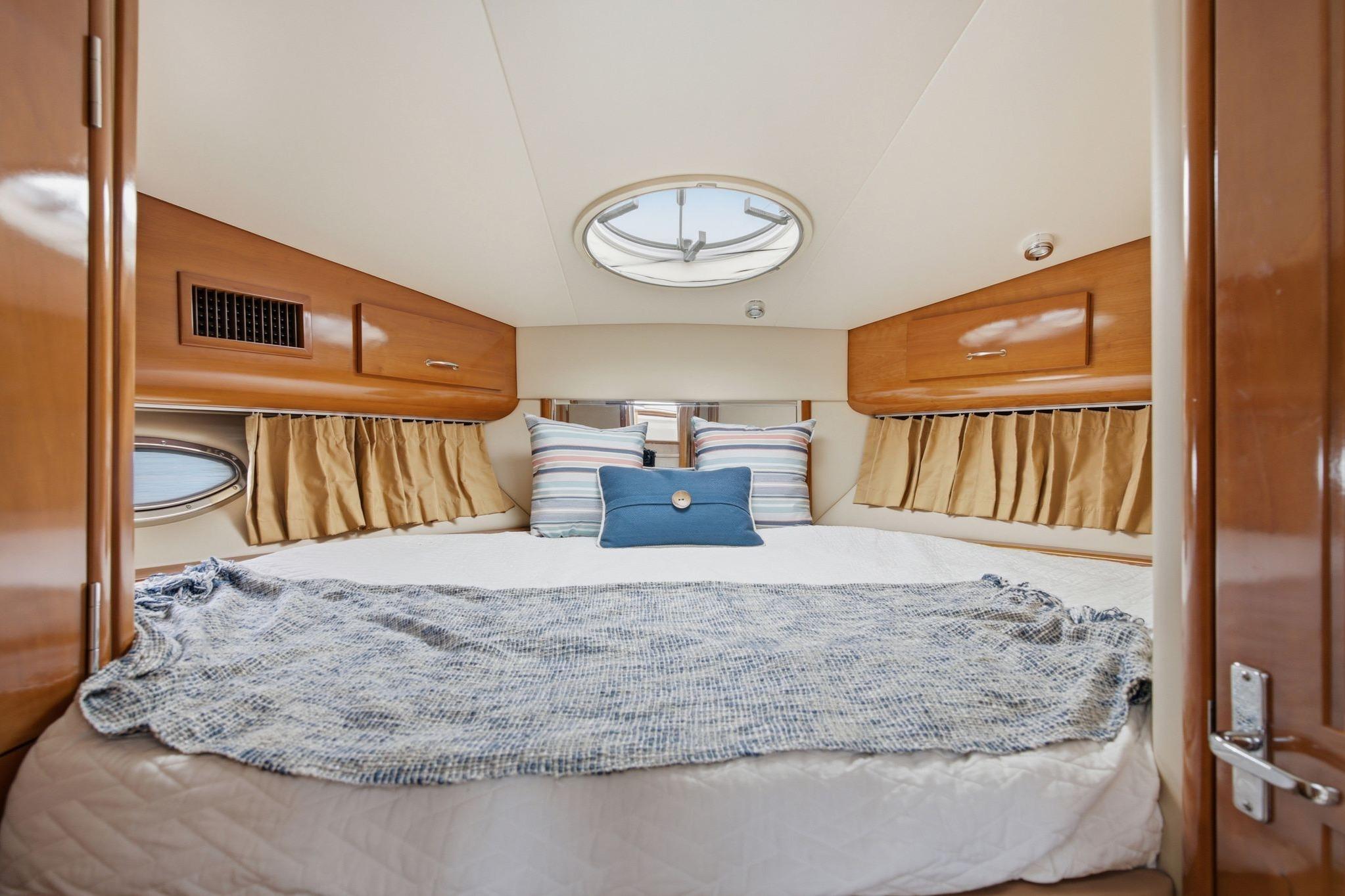 Luxurious bedroom interior of 2005 Carver 39 Motor Yacht with cozy bedding.