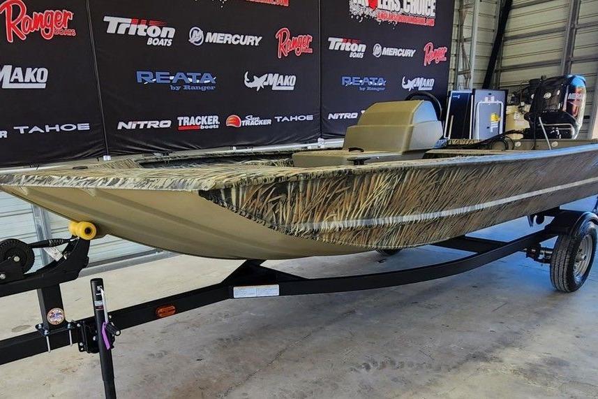 2026 Tracker Grizzly 1648 SC boat on trailer in showroom with branded backdrop.