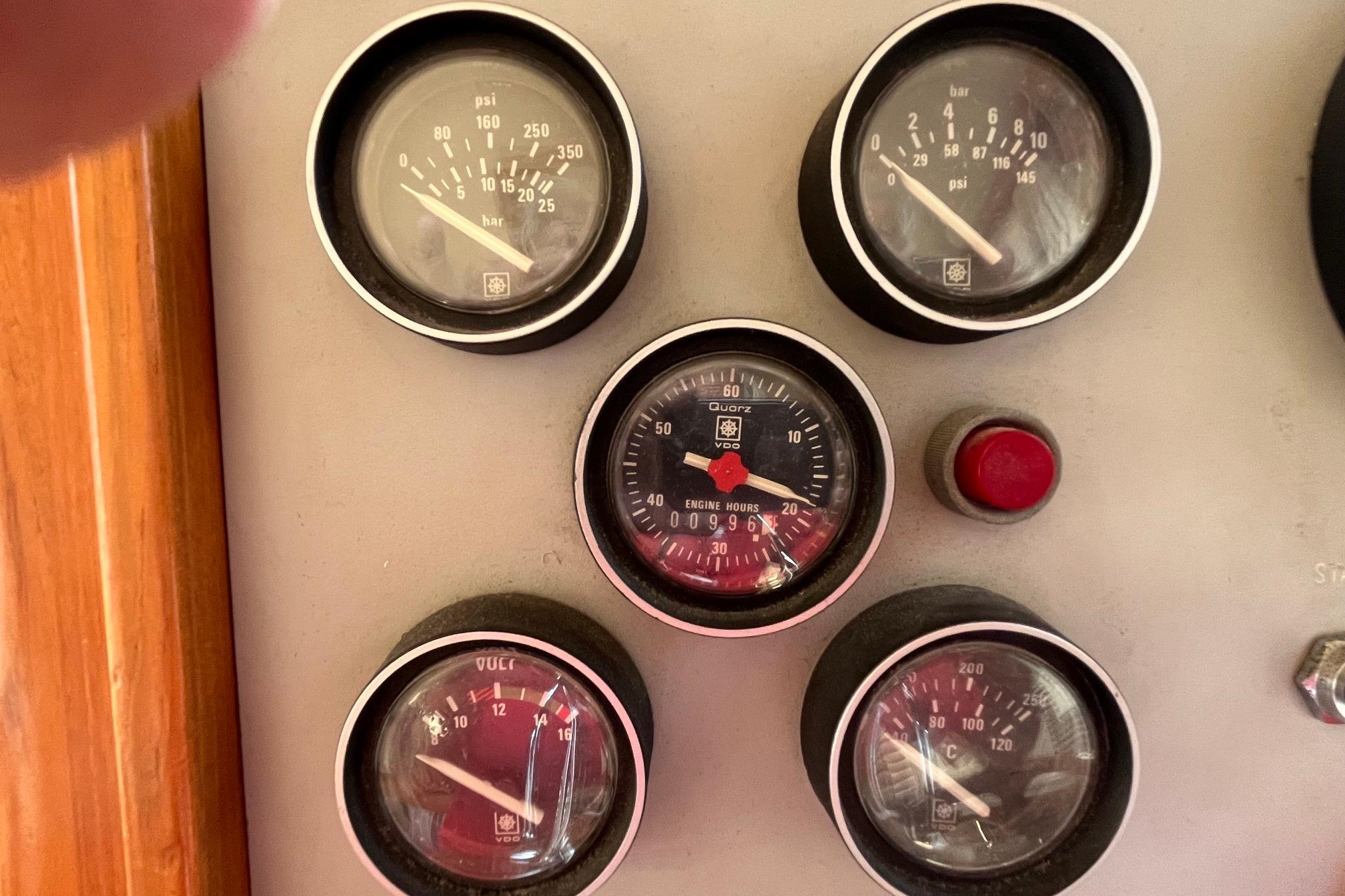 Instrument panel of 1989 Ocean Alexander 440 Sundeck CPMY with gauges and red button.