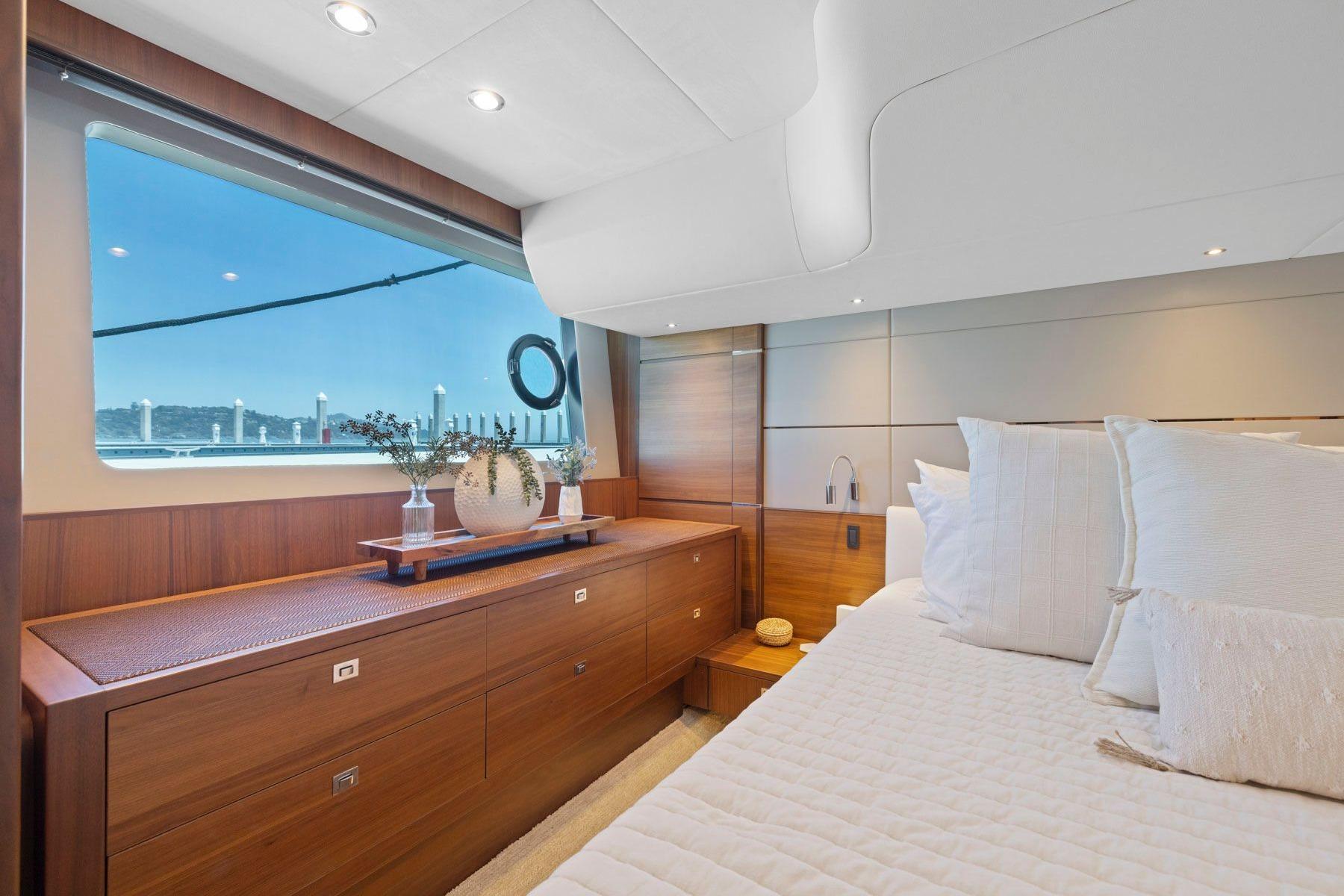 Luxurious bedroom interior of 2015 Princess 60 Flybridge Motor Yacht with elegant wood finish.
